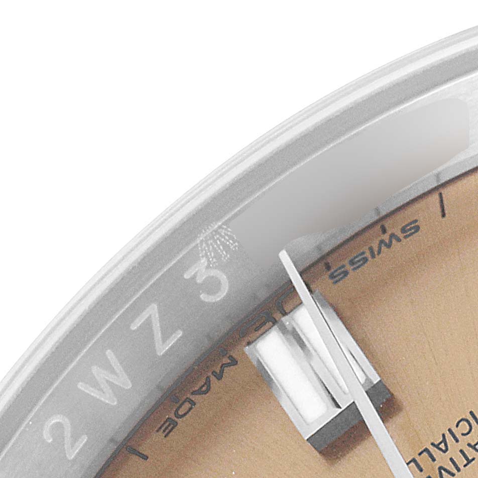 This image shows a close-up of the dial and part of the crystal of a Rolex Oyster Perpetual 116000 Men's Stainless Steel Champagne Dial 116000 Men's Stainless Steel Champagne Dial watch.