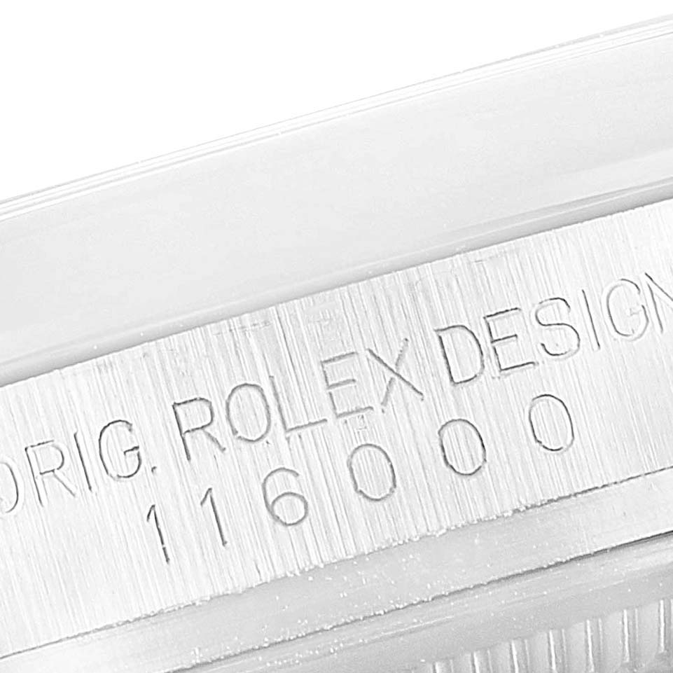This image shows a close-up of the model number engraving on the caseback rim of a Rolex Oyster Perpetual 116000 Men's Stainless Steel Champagne Dial 116000 Men's Stainless Steel Champagne Dial watch.