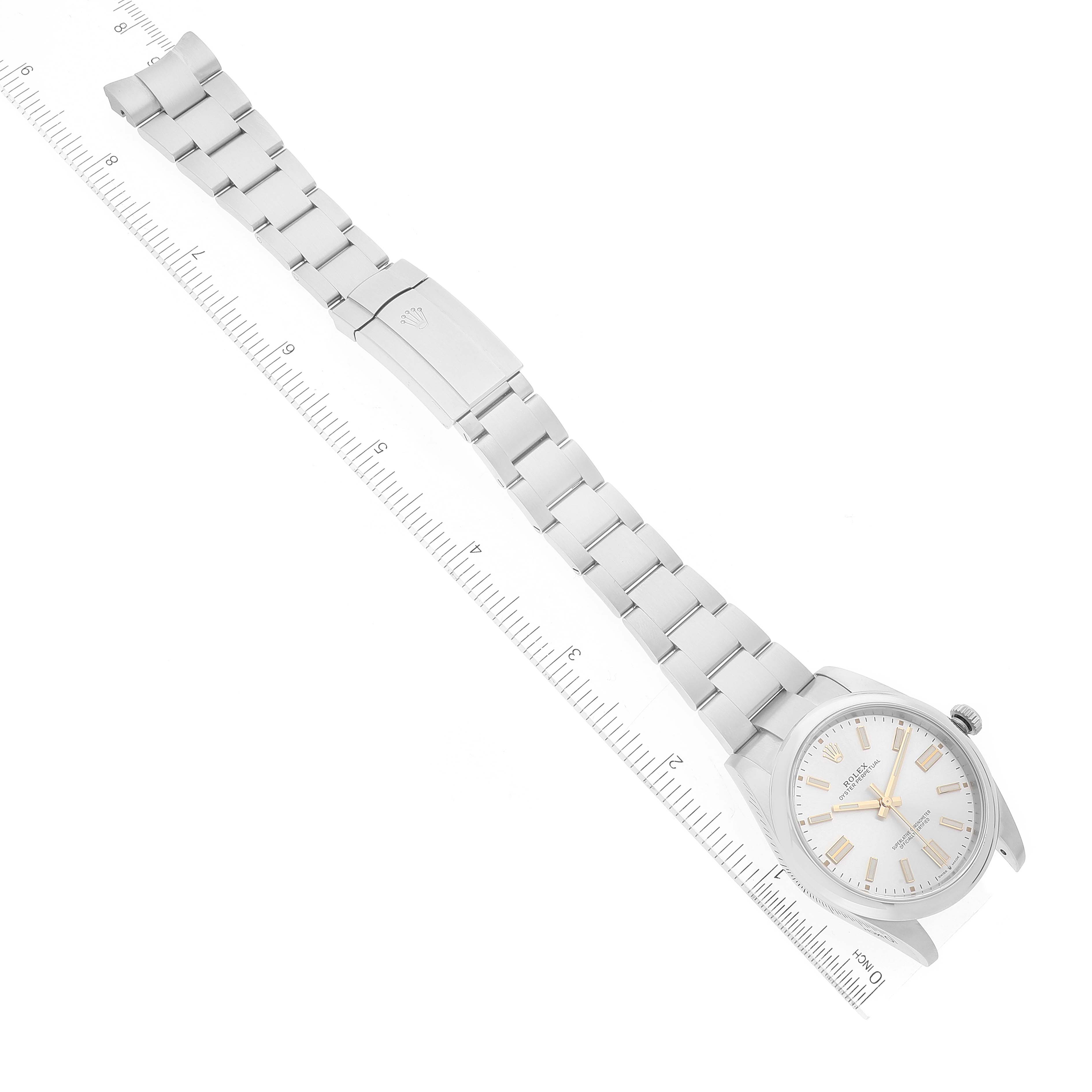 The image shows a full view of a Rolex Oyster Perpetual 124300 Men's Stainless Steel Silver Dial 124300 Men's Stainless Steel Silver Dial watch, including the face, bracelet, and clasp, positioned alongside a ruler.