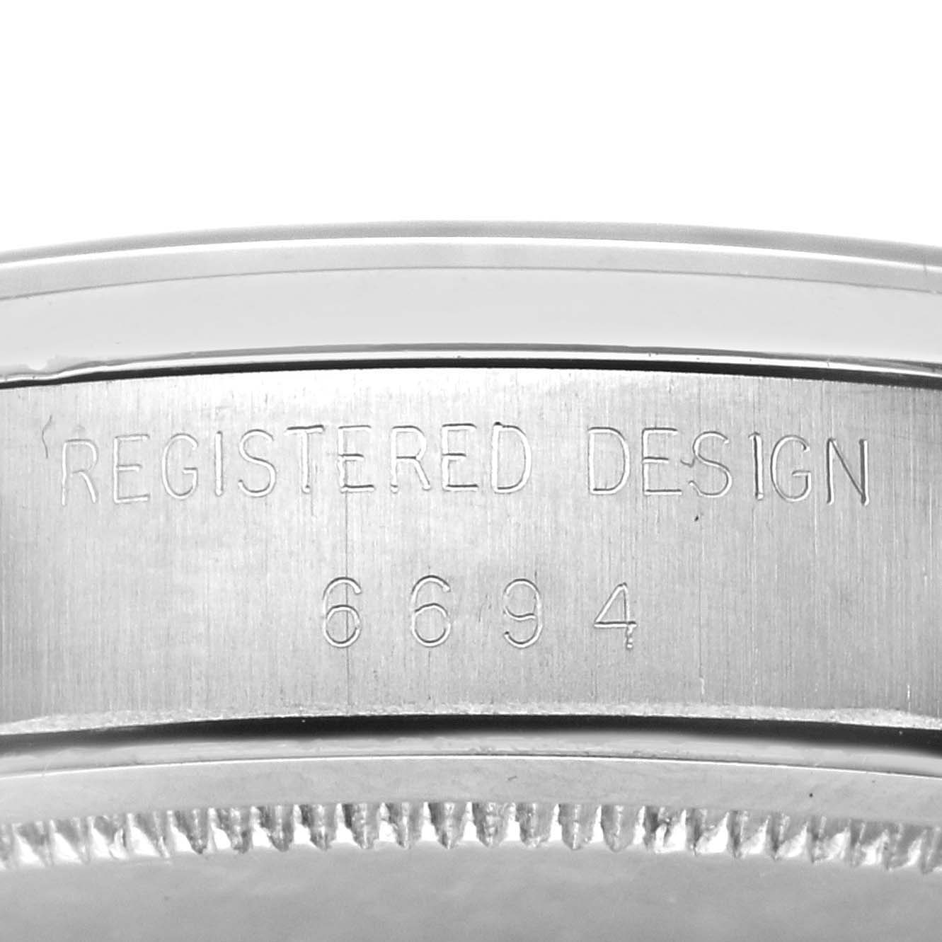 The image shows the side view of the casing for the Rolex Vintage Collection 6694 Men's Stainless Steel Champagne Dial 6694 Men's Stainless Steel Champagne Dial watch, highlighting the "REGISTERED DESIGN 6694" engraving.