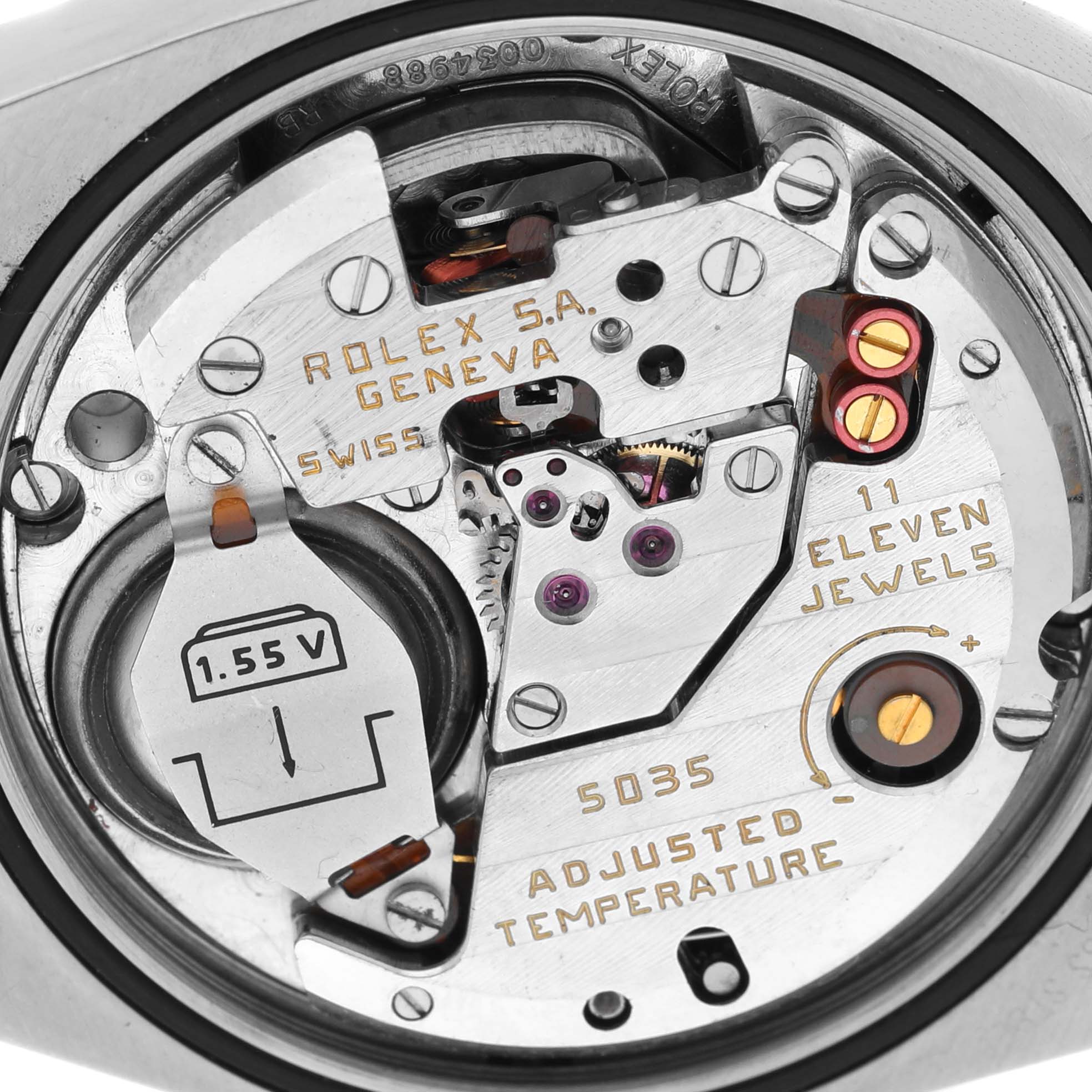 The image shows a close-up of the movement parts of a Rolex Oysterquartz 17013 Men
s Steel and Gold (two tone) Blue Dial 17013 Men
s Steel and Gold (two tone) Blue Dial watch, including the battery, jewel settings, and intricate gears.