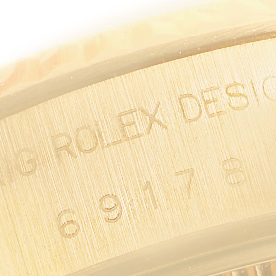 The image shows a close-up of the side view of a Rolex President 69178 Women's Yellow Gold Blue Dial 69178 Women's Yellow Gold Blue Dial model watch, highlighting the engraved text and numbers.