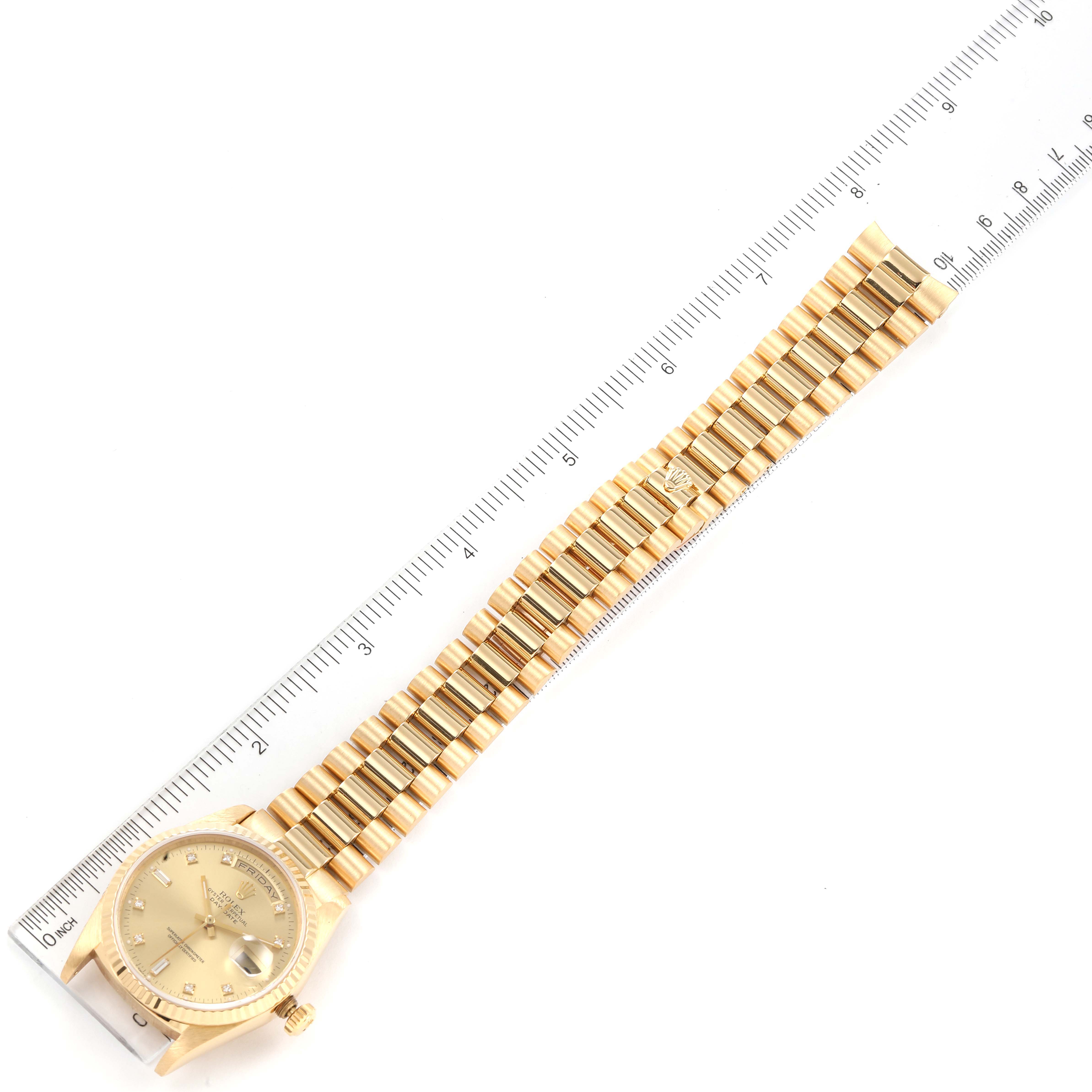 The image shows a Rolex President 18238 Men's Yellow Gold Champagne Dial 18238 Men's Yellow Gold Champagne Dial model watch laid flat next to a ruler, displaying its gold bracelet and dial from a top-down angle.