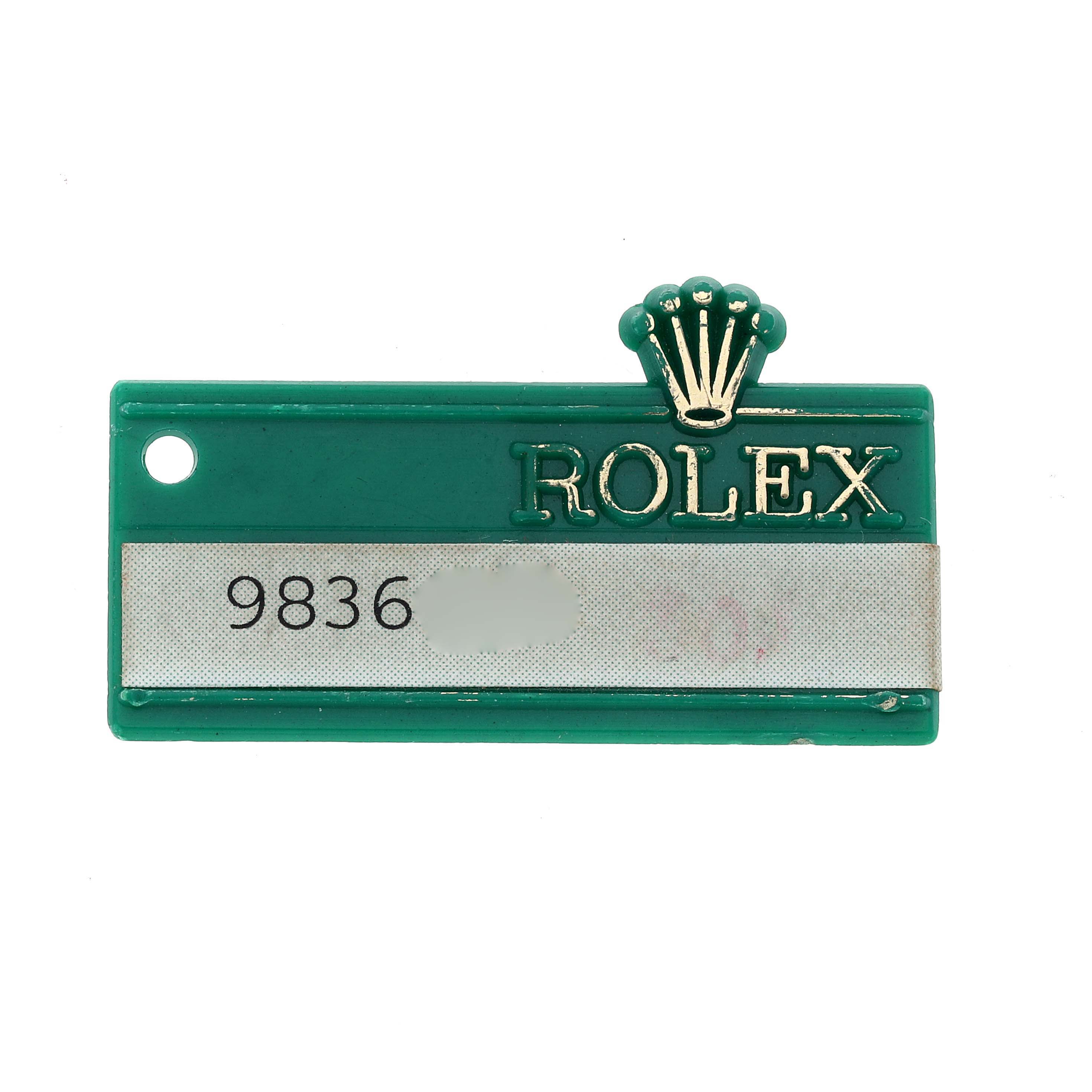 This image shows a green Rolex tag for the President model with the brand logo and a partially obscured number.
