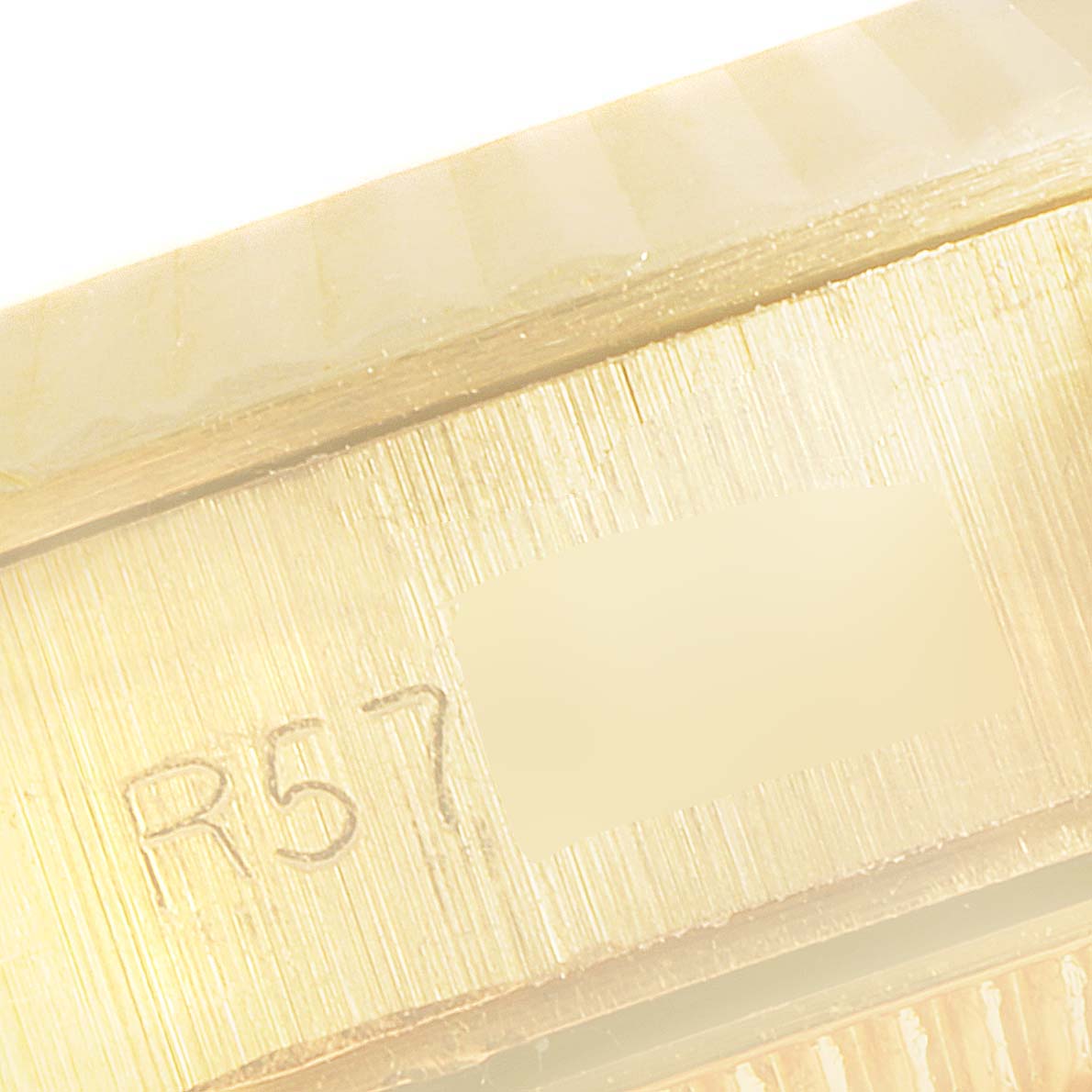 The image shows a close-up of a section of the Rolex President 67198 Women's Yellow Gold Champagne Dial 67198 Women's Yellow Gold Champagne Dial model watch case with part of the serial number visible.
