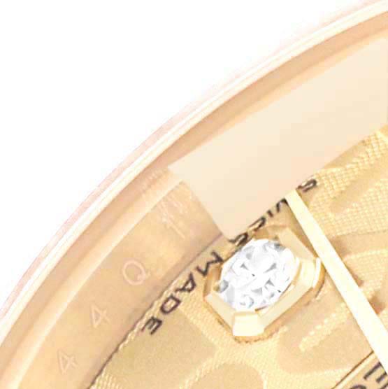 This close-up image of a Rolex President 179138 Women's Yellow Gold Champagne Dial 179138 Women's Yellow Gold Champagne Dial model watch shows a portion of the gold dial and diamond marker.