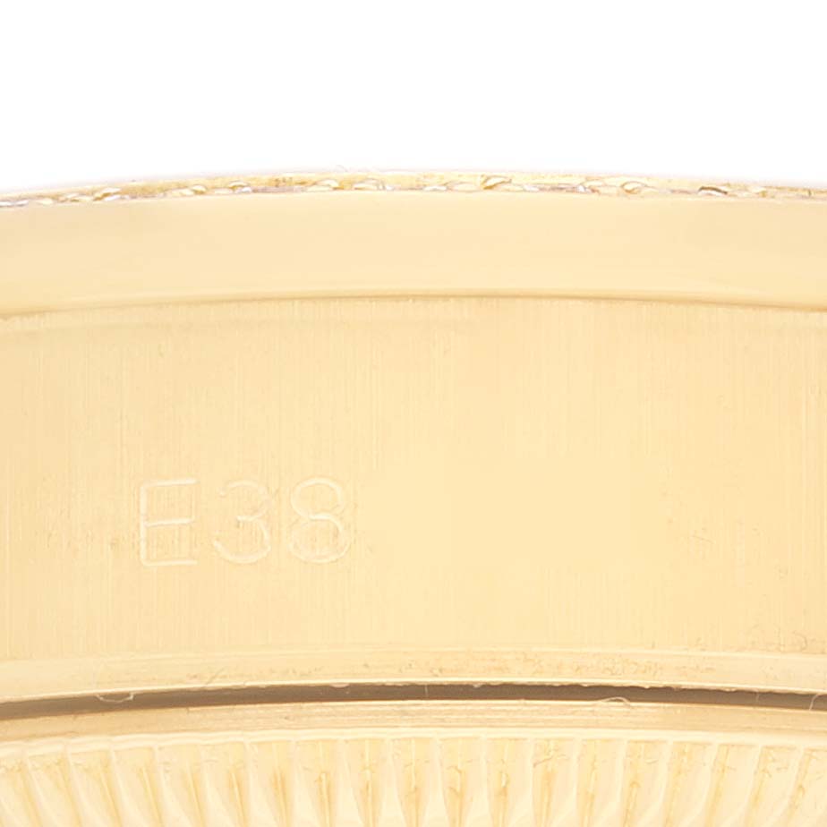 This close-up image shows the side of the bezel of a Rolex President 69158 Women
s Yellow Gold Champagne Dial 69158 Women
s Yellow Gold Champagne Dial model with an engraved "E38" mark.