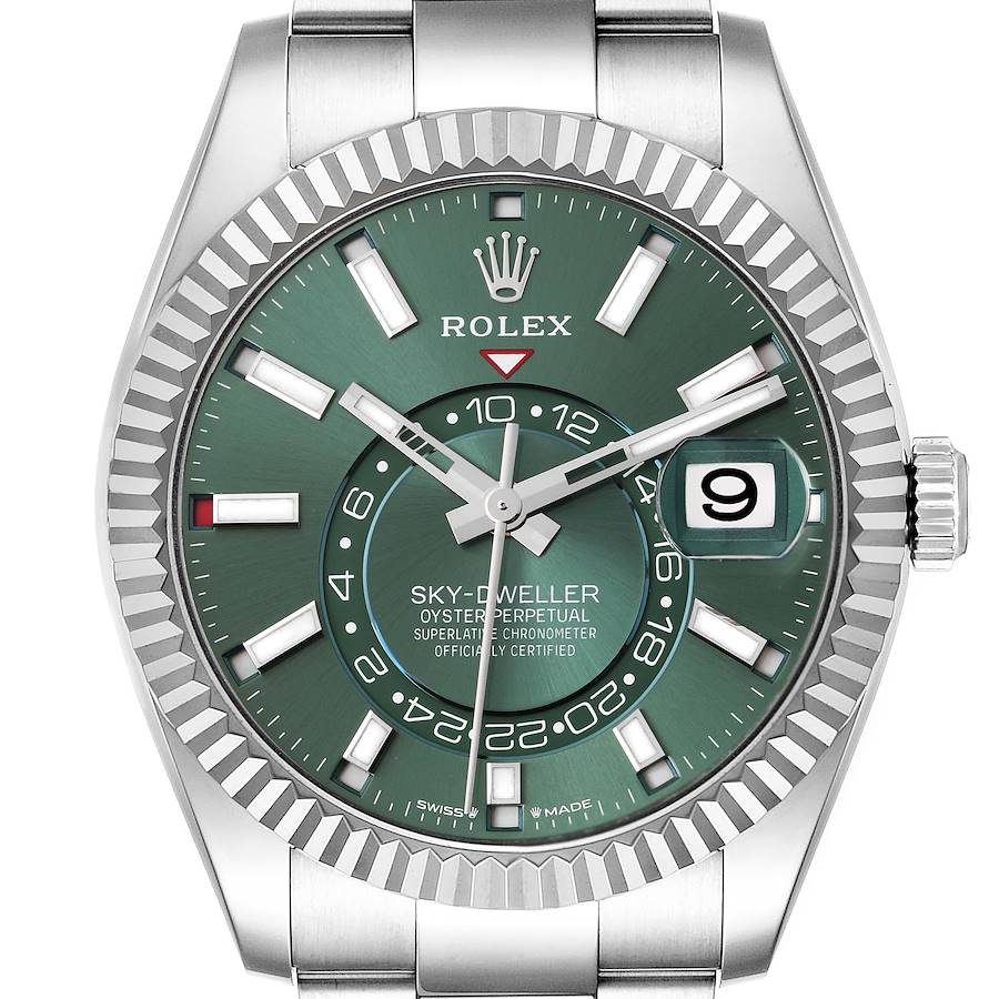 The image shows a frontal view of the Rolex Sky-Dweller watch, featuring a green dial, fluted bezel, and date window.