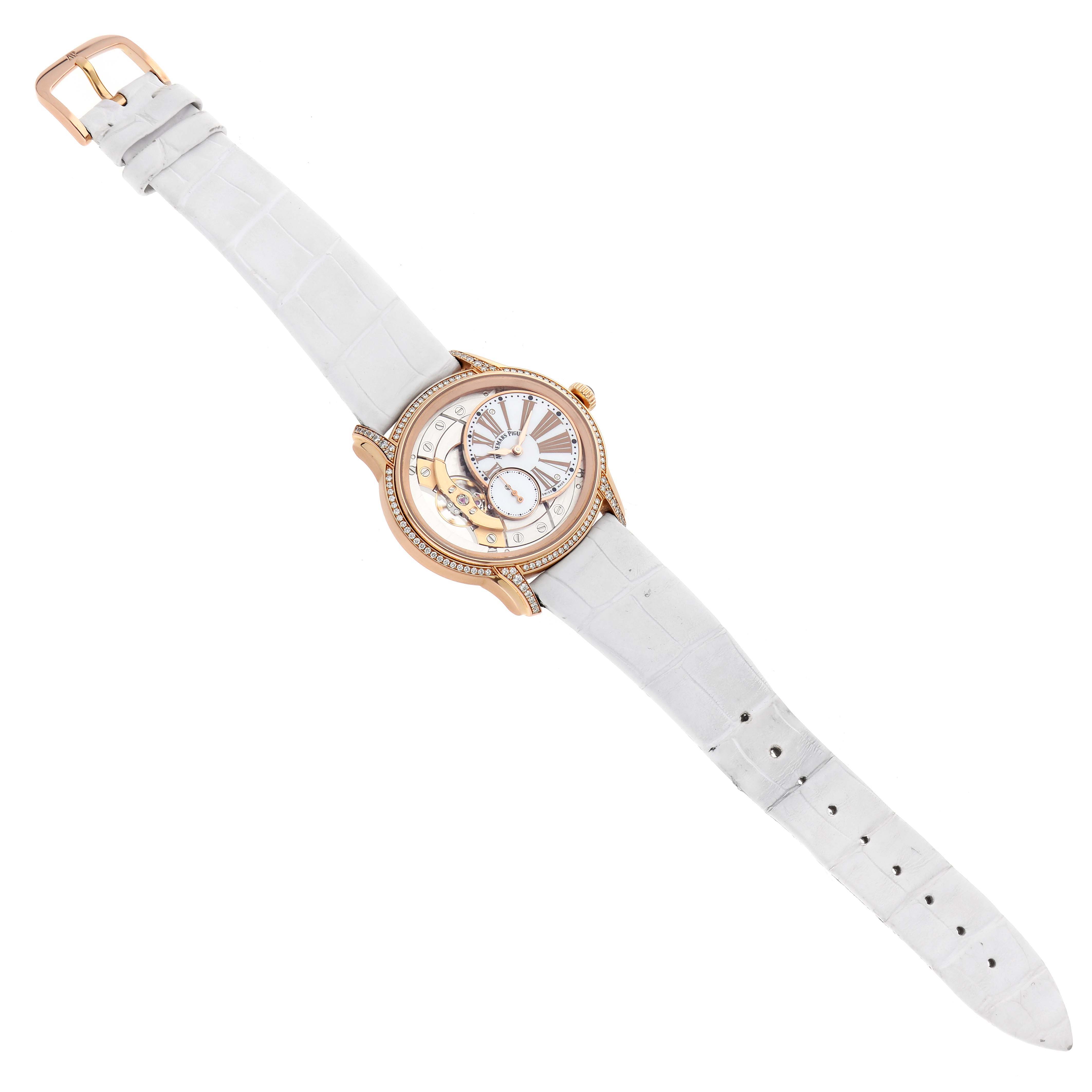 The Audemars Piguet Millenary 77247OR Women
s Rose Gold Transparent Dial watch is shown from a top-down angle, highlighting its white strap and detailed dial.