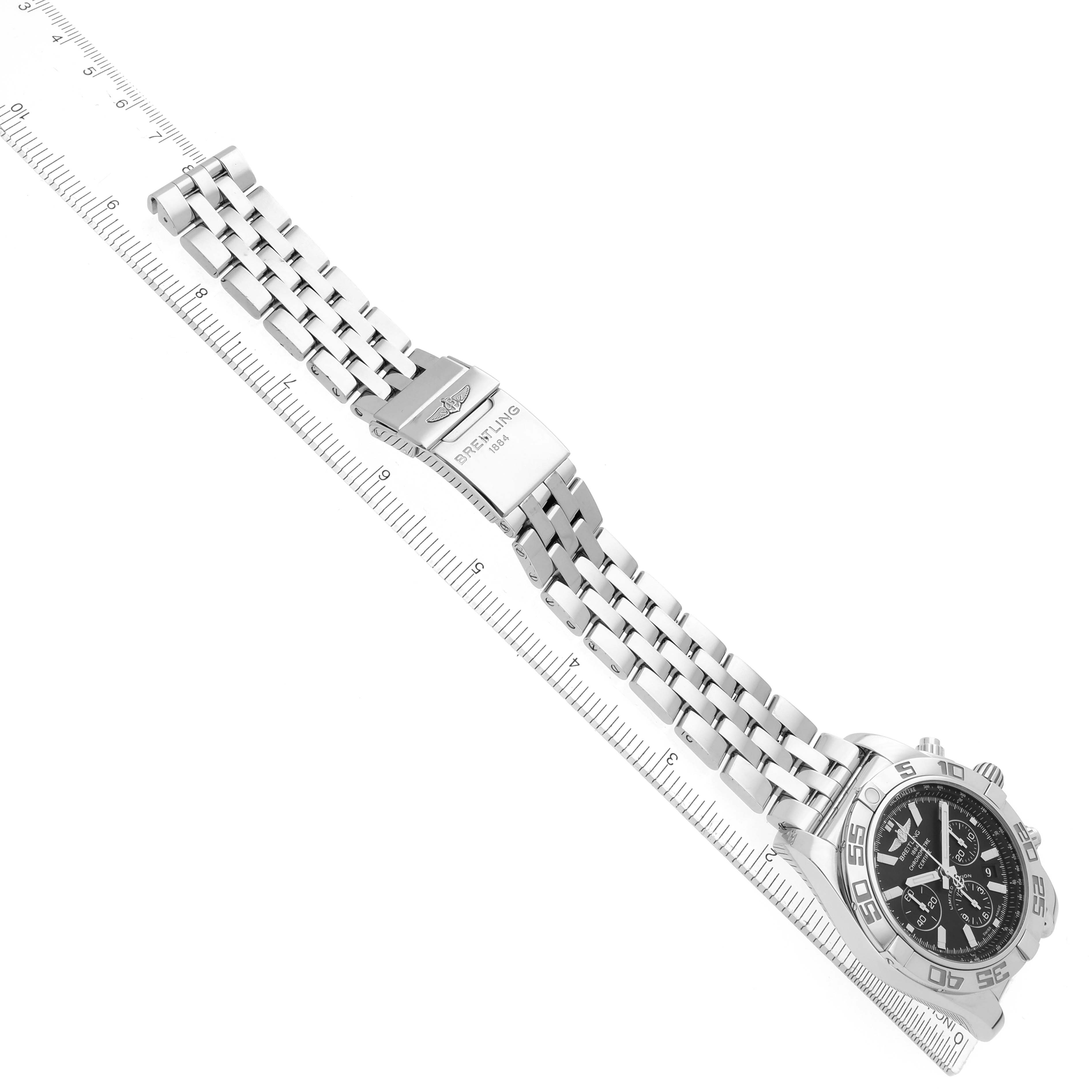 The image shows a Breitling Chronomat AB0111 Men
s Stainless Steel Black Dial watch at an angle, displaying the bracelet, clasp, and part of the face with a ruler for scale.