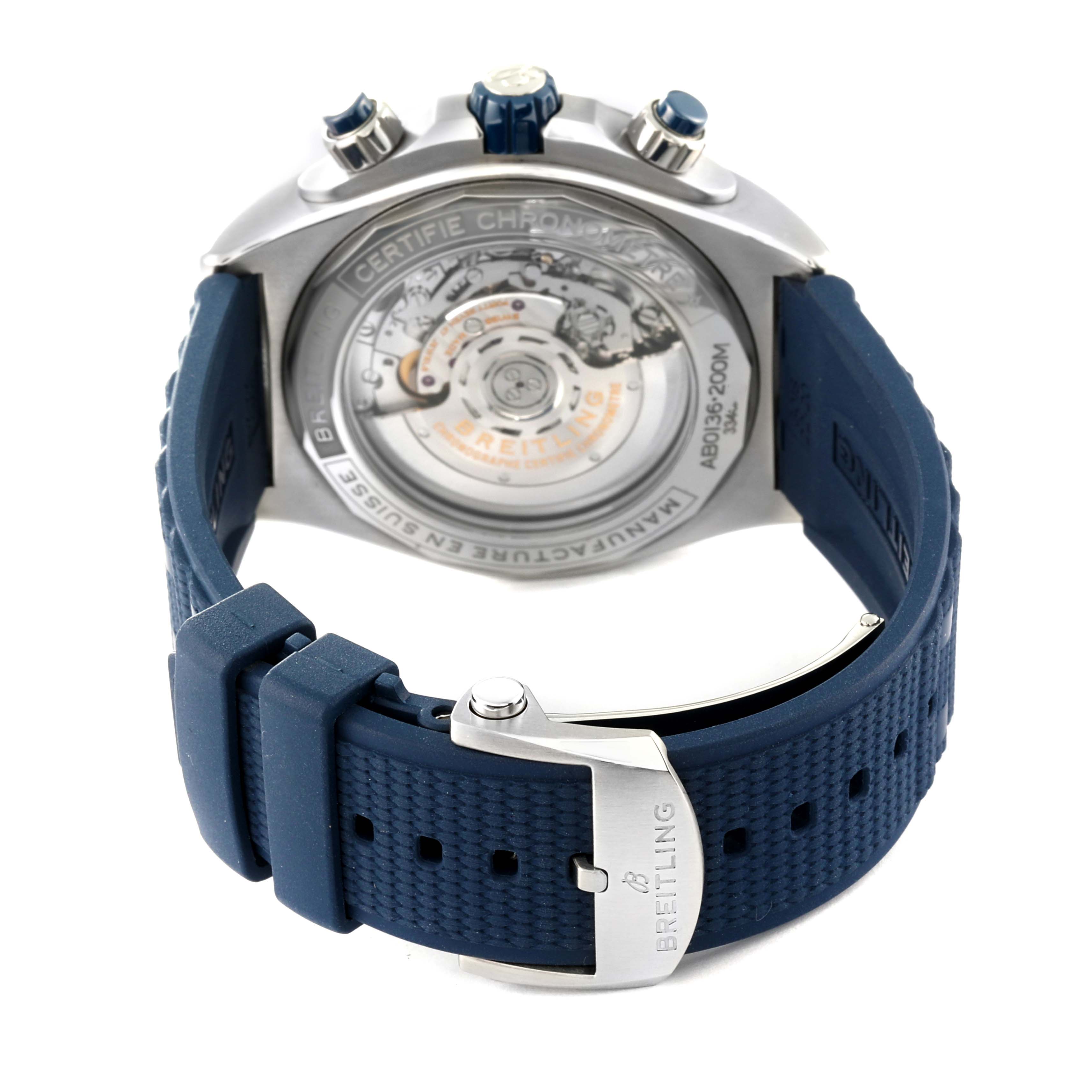 The image shows the Breitling Chronomat AB0136251B1A2 Men's Stainless Steel Blue Dial AB0136251B1A2 Men's Stainless Steel Blue Dial watch from the back, highlighting its open case back and blue rubber strap with a branded clasp.