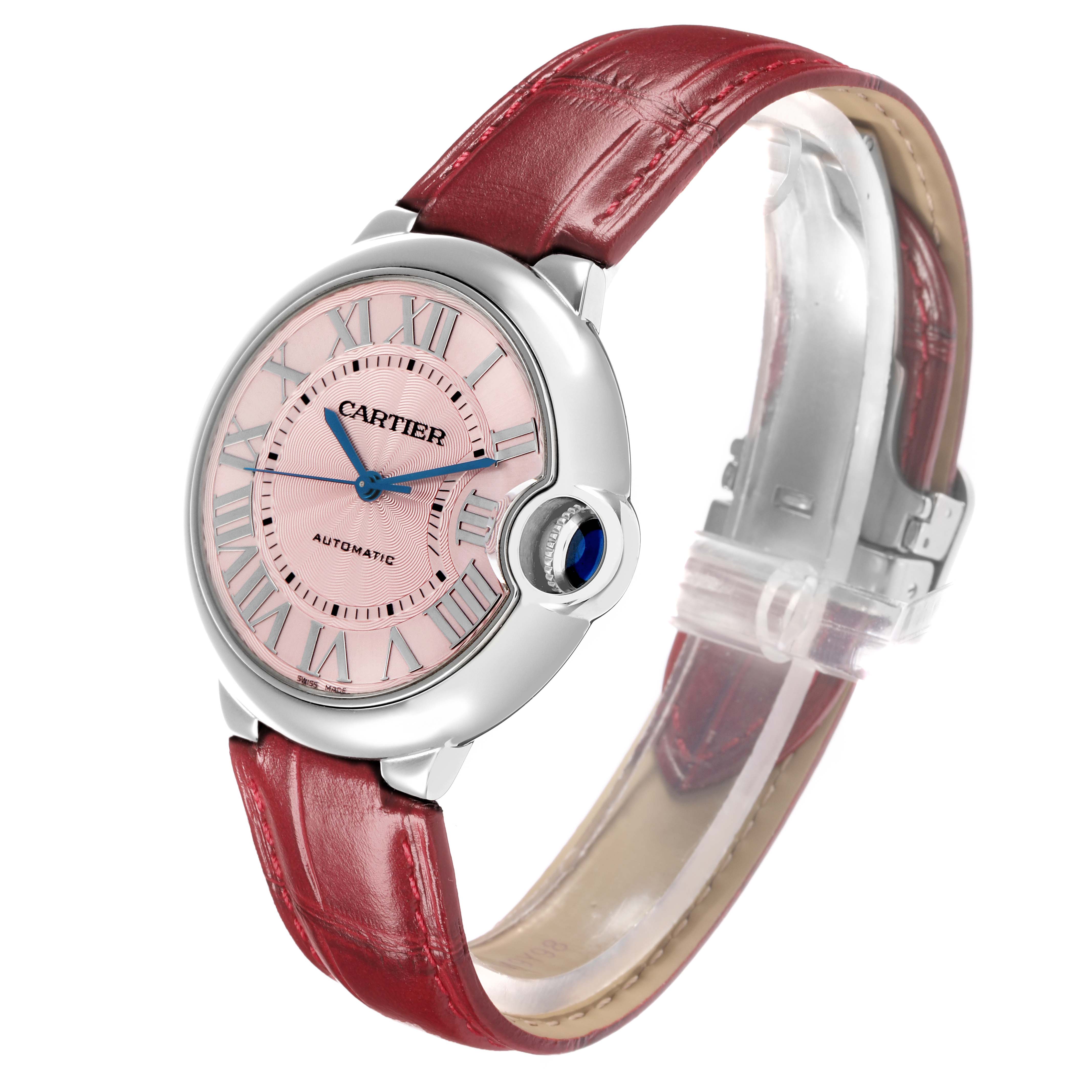 The Cartier Ballon Bleu WSBB0007 Women
s Stainless Steel Pink Dial watch is shown at an angle highlighting the dial, crown, and red leather strap.