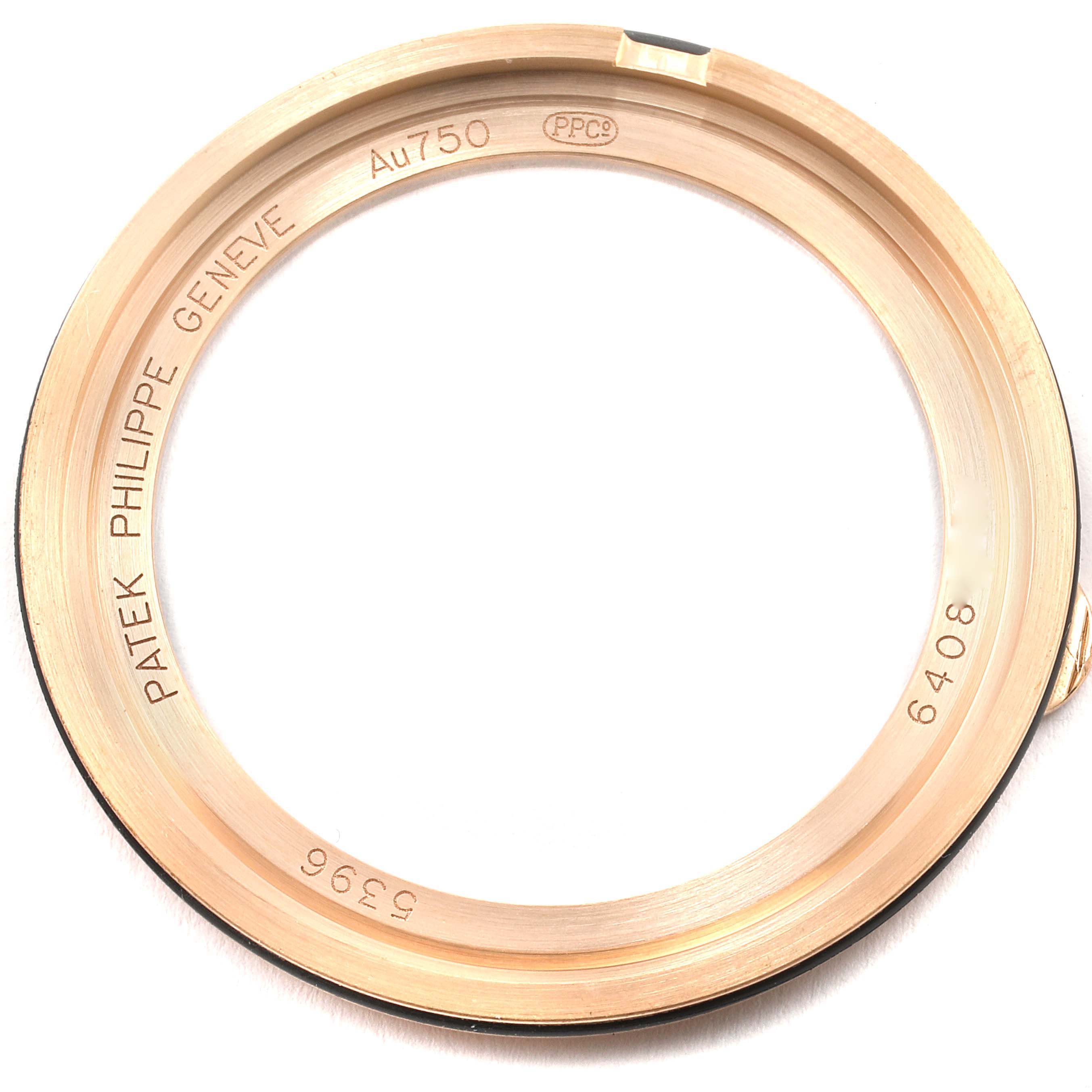 The image shows a close-up of the bezel of a Patek Philippe Complications 5396R Men's Rose Gold Blue Dial 5396R Men's Rose Gold Blue Dial model watch, featuring inscriptions and hallmarks.