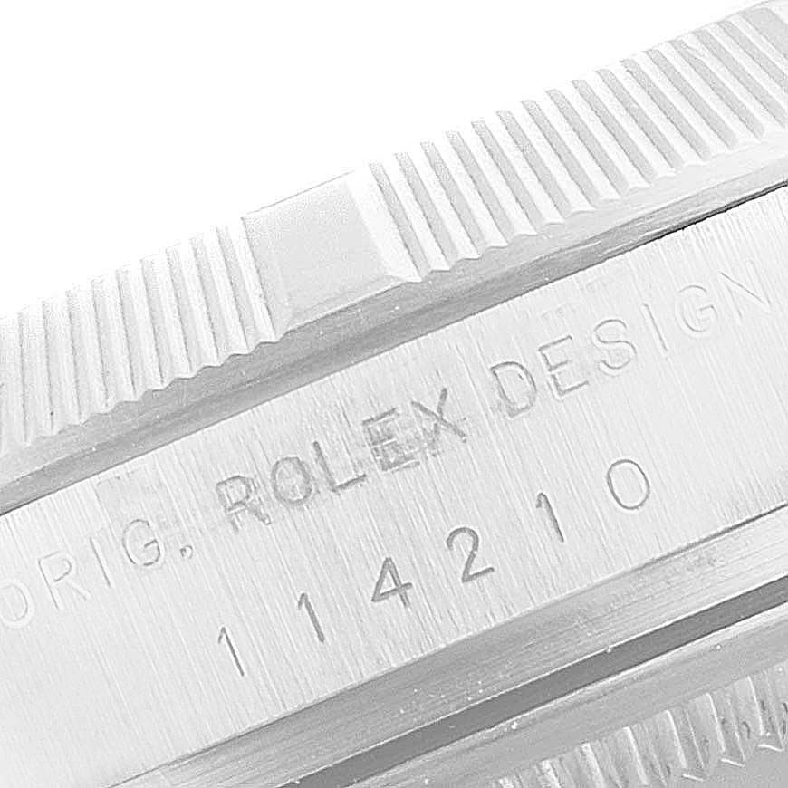 The image shows a close-up of the engraved side and fluted bezel of a Rolex Air-King 114210 Men's Stainless Steel White Dial 114210 Men's Stainless Steel White Dial watch.