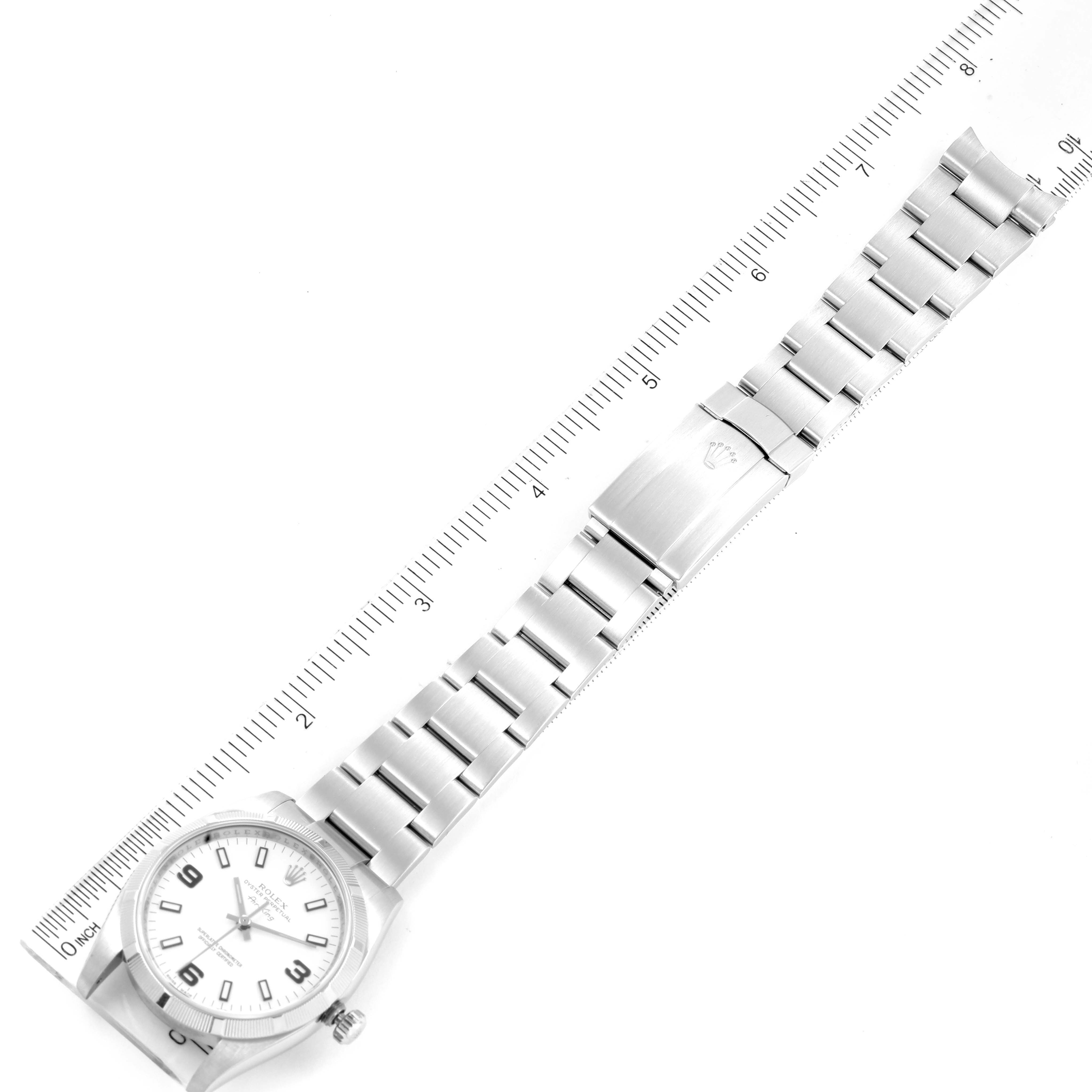 The image shows a top-down view of a Rolex Air-King 114210 Men's Stainless Steel White Dial 114210 Men's Stainless Steel White Dial watch, highlighting the bracelet and clasp next to a ruler for scale.