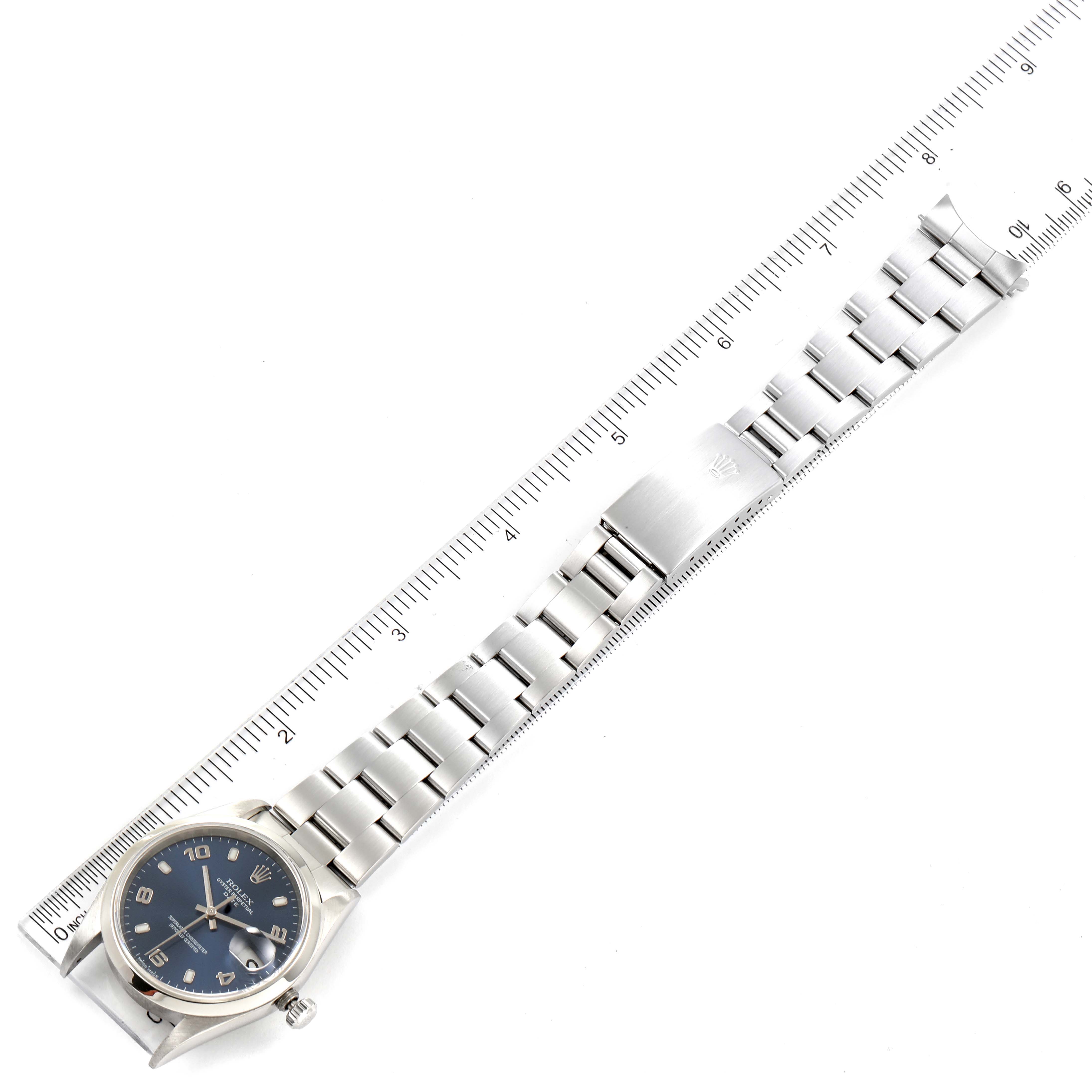 The image shows a Rolex Date 15200 Men's Stainless Steel Blue Dial 15200 Men's Stainless Steel Blue Dial watch laid flat with the full bracelet and clasp visible, aligned next to a ruler.
