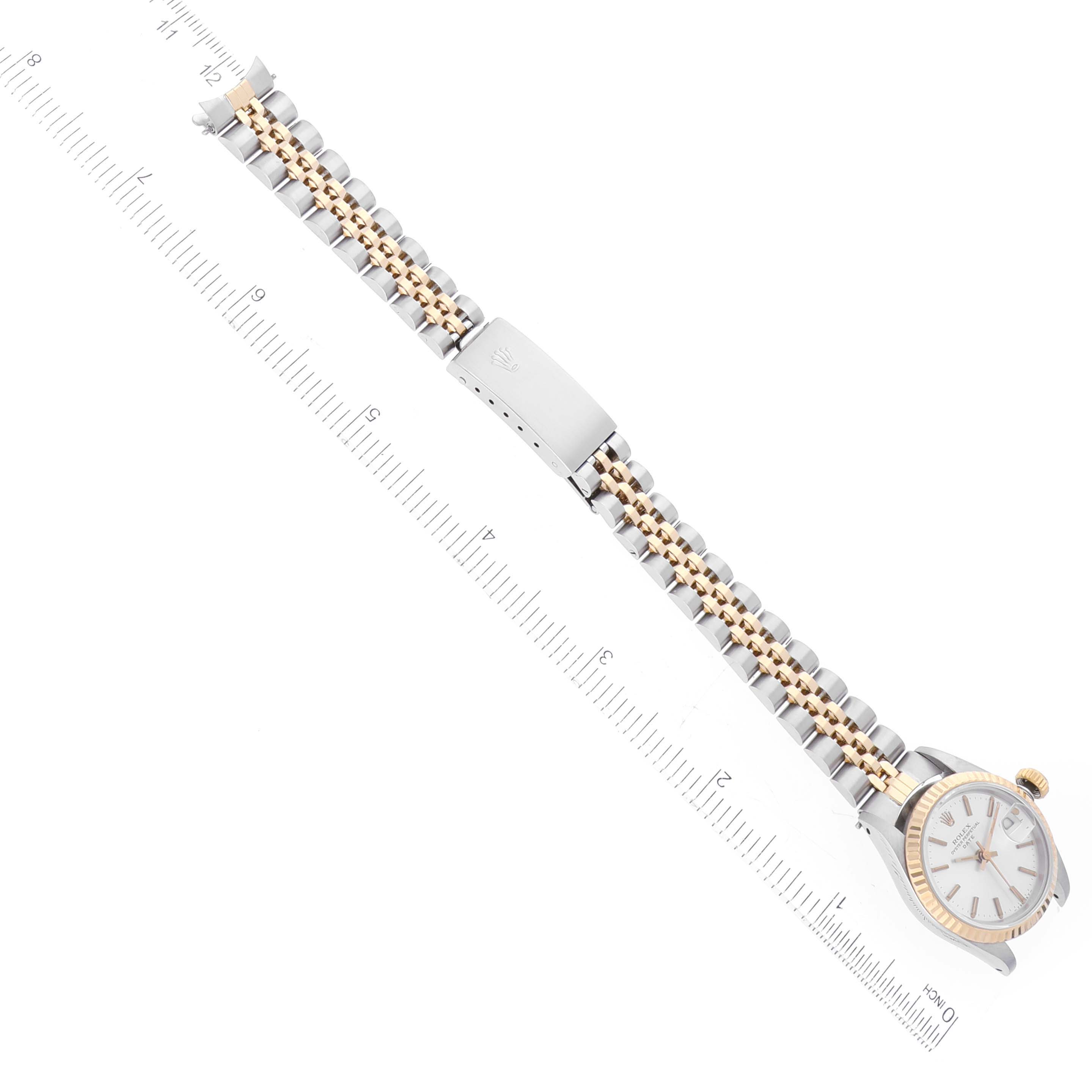 The image shows a Rolex Date 69173 Women's Steel and Gold (two tone) Silver Dial 69173 Women's Steel and Gold (two tone) Silver Dial watch from a top-down angle, highlighting the face, two-tone bracelet, and clasp, alongside a measurement ruler.