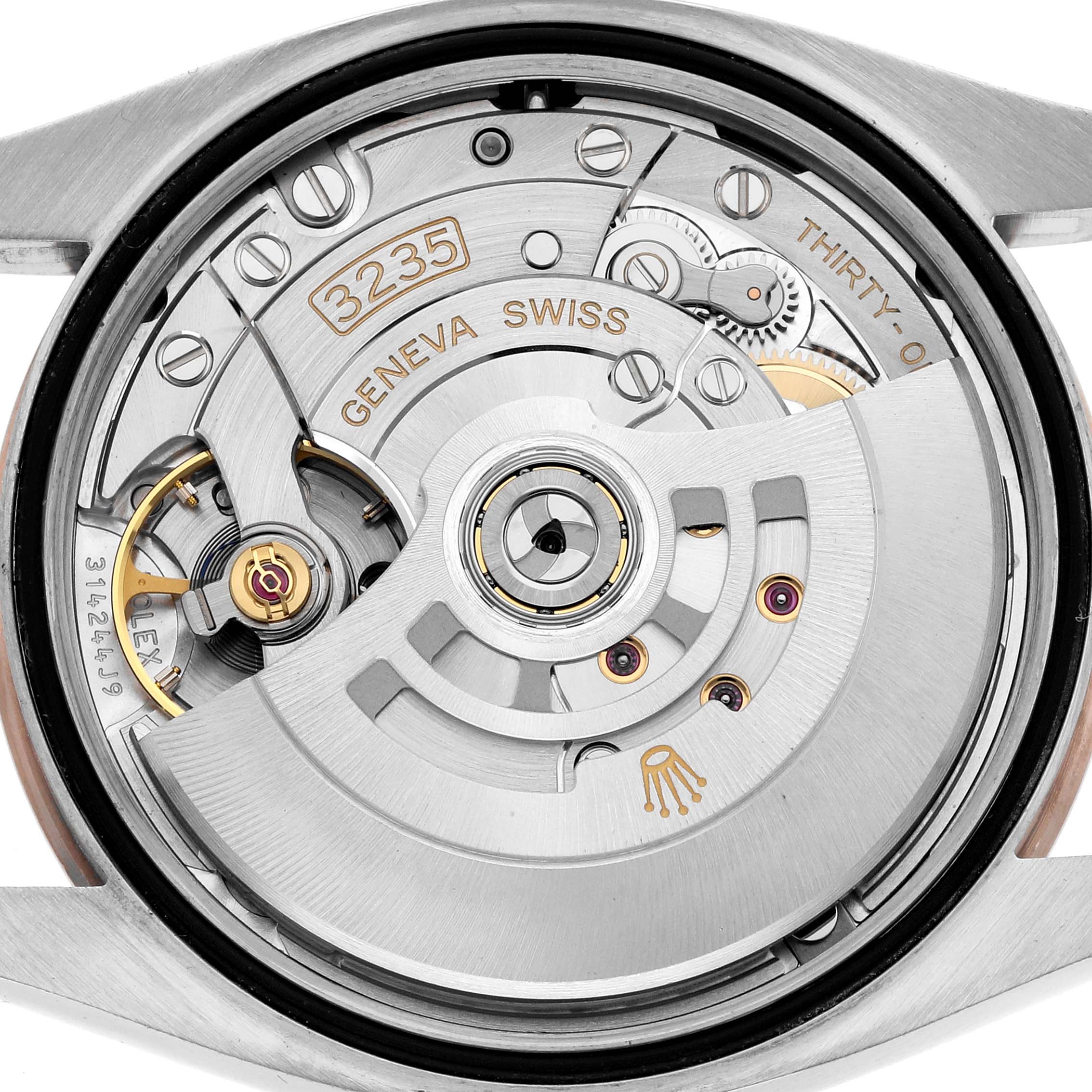 The image shows the back view of a Rolex Datejust 126201 Men
s Steel and Gold (two tone) Black Dial, revealing its exposed movement and rotor details.