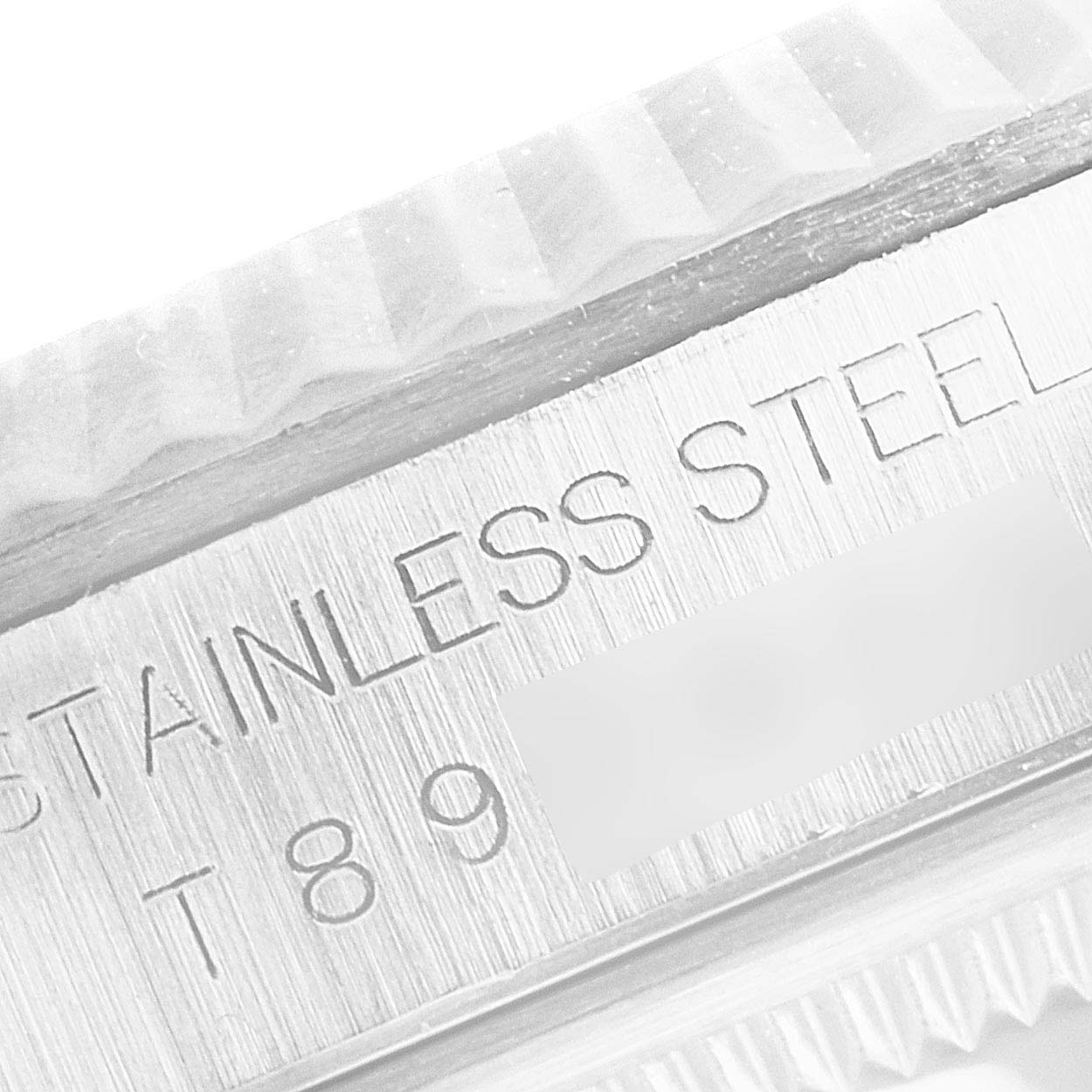 The image shows a close-up of the etched "Stainless Steel" text on the case of a Rolex Datejust 16234 Men's Stainless Steel Blue Dial 16234 Men's Stainless Steel Blue Dial watch.