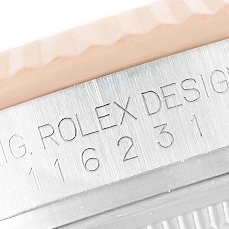 This image shows a close-up of the serial engraving on a Rolex Datejust 116231 Men's Steel and Gold (two tone) Pink Dial 116231 Men's Steel and Gold (two tone) Pink Dial watch bezel.