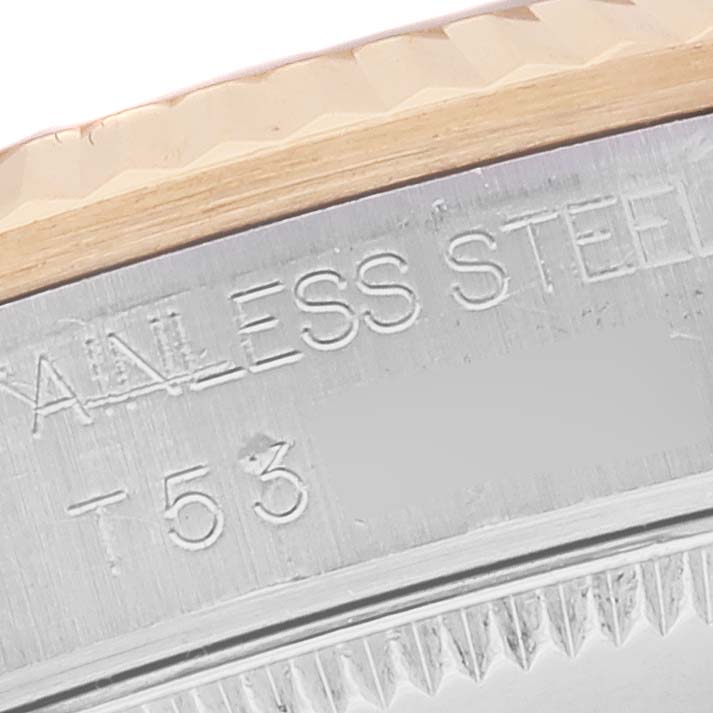 This close-up shows the Rolex Mid-Size 68273 Women's Steel and Gold (two tone) Mother of Pearl Dial 68273 Women's Steel and Gold (two tone) Mother of Pearl Dial model's fluted bezel and engraved "STAINLESS STEEL" marking on the case side.