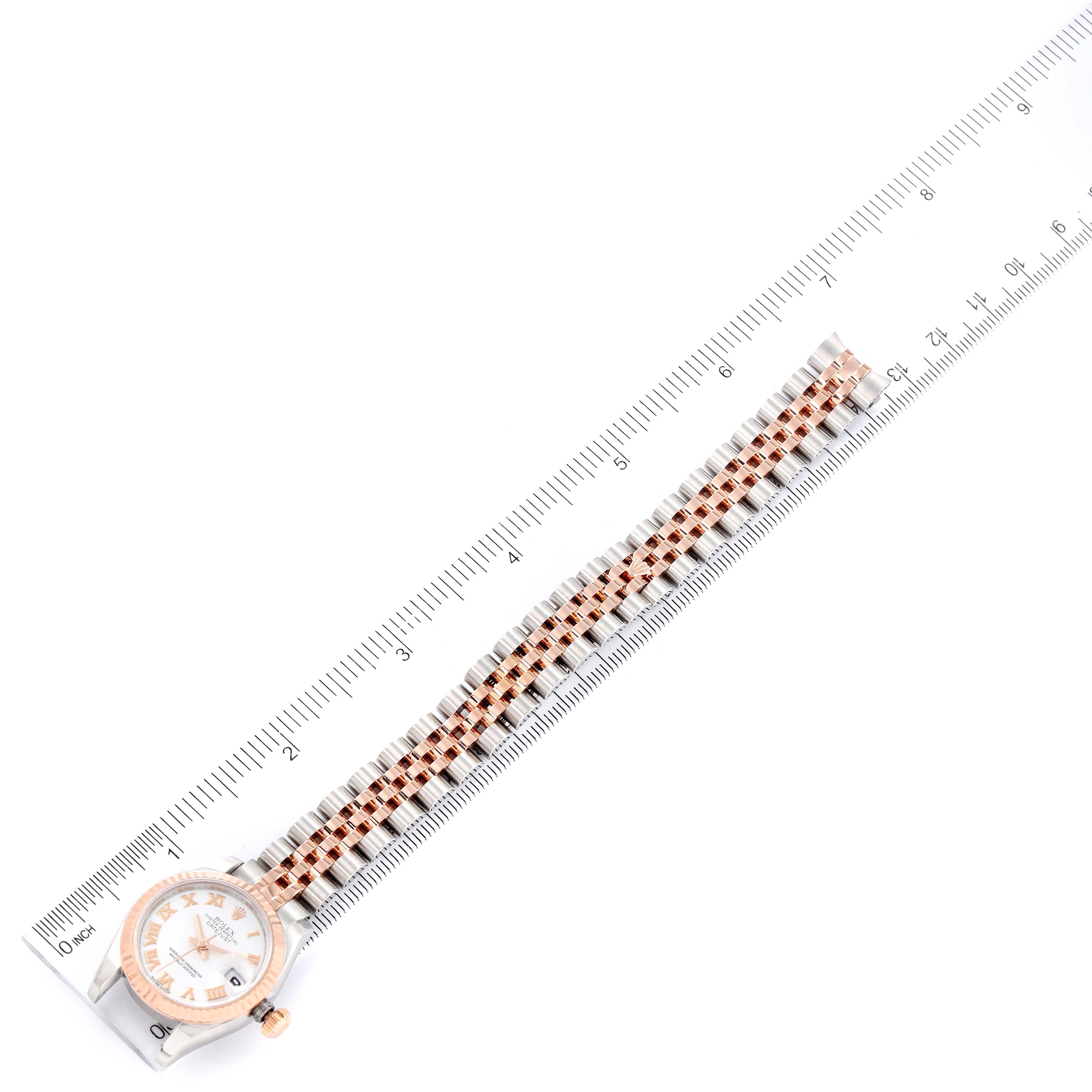 This image shows the Rolex Datejust 179171 Women's Steel and Gold (two tone) White Dial 179171 Women's Steel and Gold (two tone) White Dial watch from a top-down angle alongside a ruler for scale, focusing on the band and face.