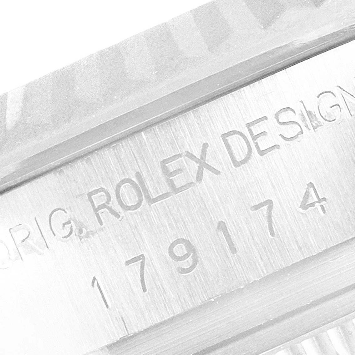 This close-up image shows the engraved serial number and "Rolex Design" on the case body of a Rolex Datejust 179174 Women's Stainless Steel Black Dial 179174 Women's Stainless Steel Black Dial watch.