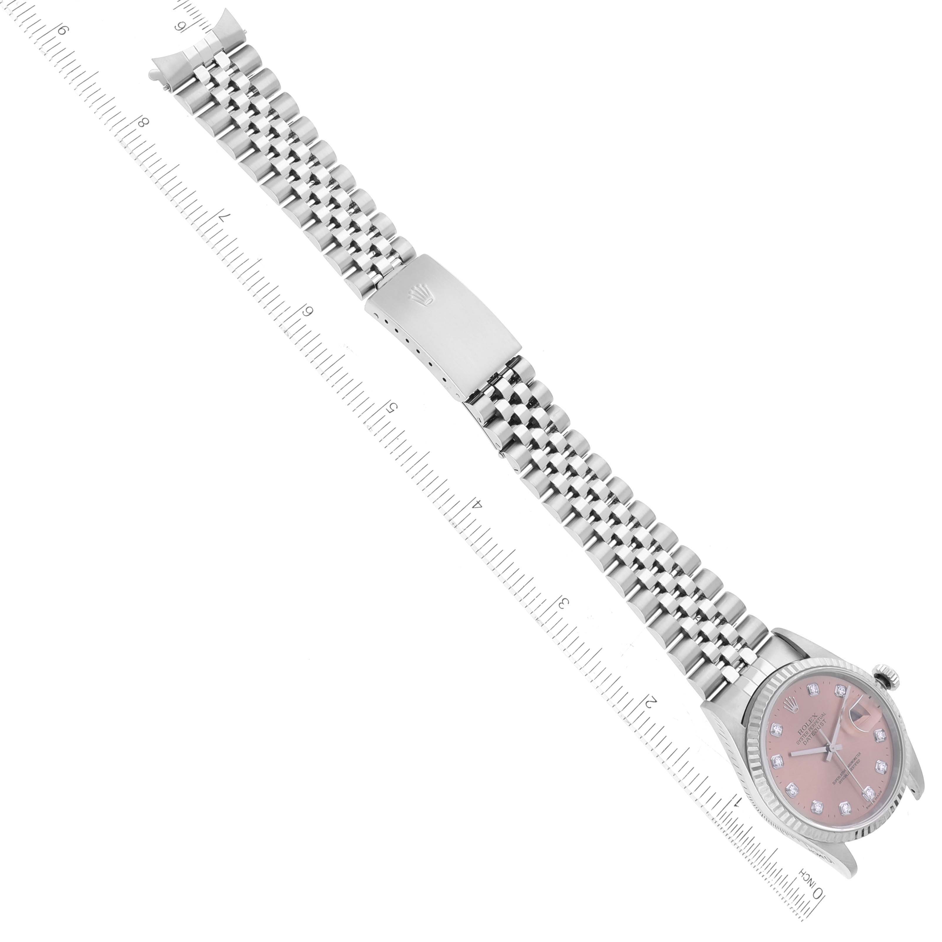 The image shows the Rolex Datejust 16234 Men's Stainless Steel Pink Dial 16234 Men's Stainless Steel Pink Dial watch laid flat with a pink dial and stainless steel bracelet, measured alongside a ruler.