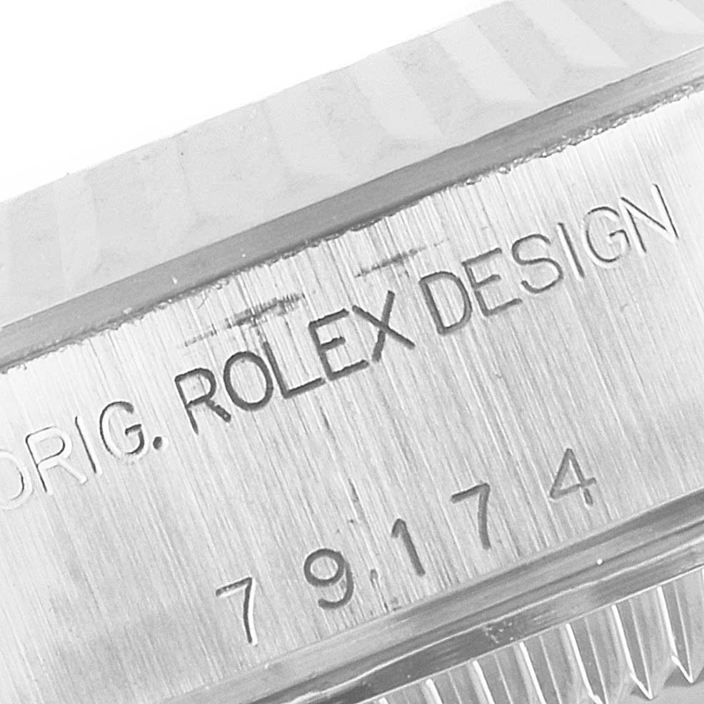 The image displays an angled close-up of the case side of the Rolex Datejust 79174 Women
s Stainless Steel White Dial 79174 Women
s Stainless Steel White Dial, showing the model number and "Rolex Design" engraving.