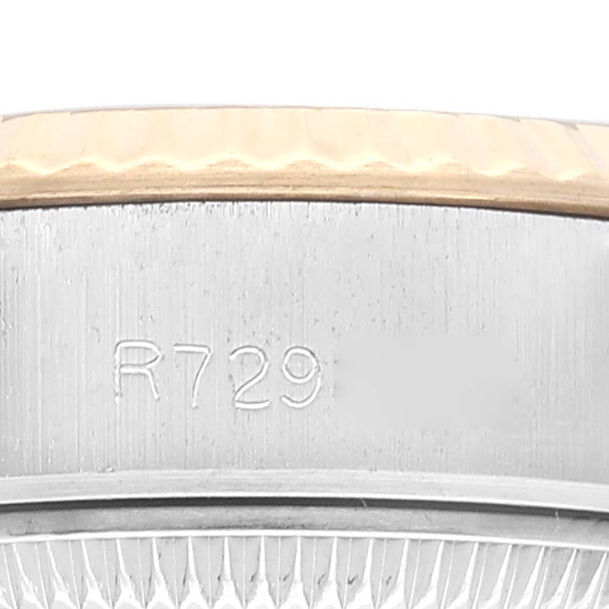 This close-up image of the Rolex Datejust 69173 Women's Steel and Gold (two tone) Champagne Dial 69173 Women's Steel and Gold (two tone) Champagne Dial watch features the edge of the bezel and part of the watch case with an engraving.
