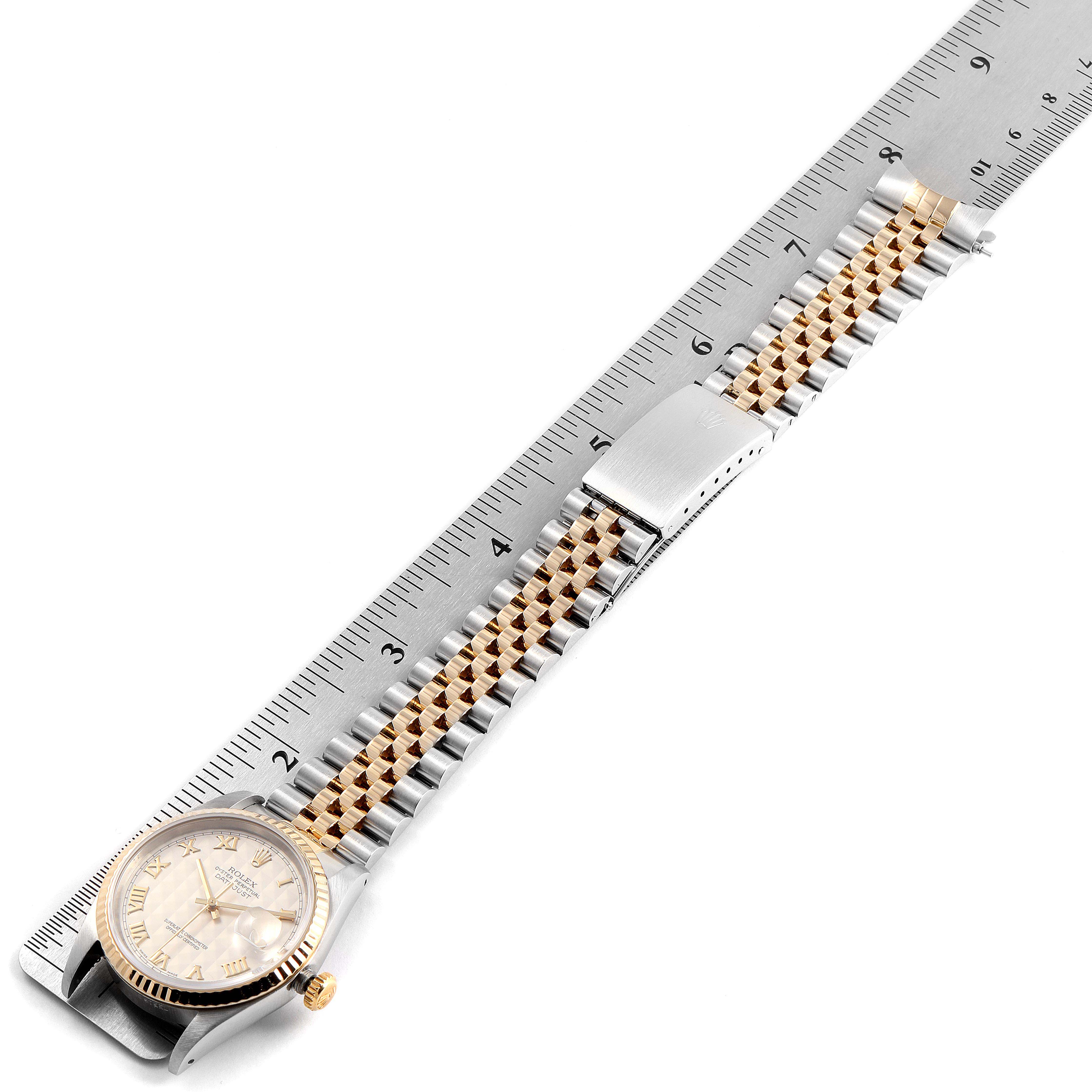 The Rolex Datejust 16233 Men's Steel and Gold (two tone) Silver Dial 16233 Men's Steel and Gold (two tone) Silver Dial watch is shown from a top view with its full band extended and measured against a ruler.