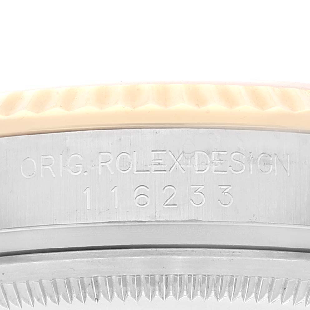 Close-up of the side of a Rolex Datejust 116233 Men's Steel and Gold (two tone) Silver Dial 116233 Men's Steel and Gold (two tone) Silver Dial, showing the engraving "ORIG ROLEX DESIGN" and the model number "116233."