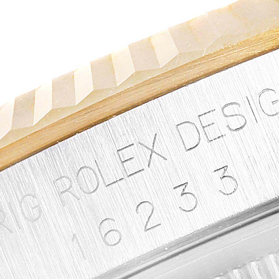 This close-up image shows the fluted bezel and part of the engraved case side of a Rolex Datejust 16233 Men's Steel and Gold (two tone) White Dial 16233 Men's Steel and Gold (two tone) White Dial watch.