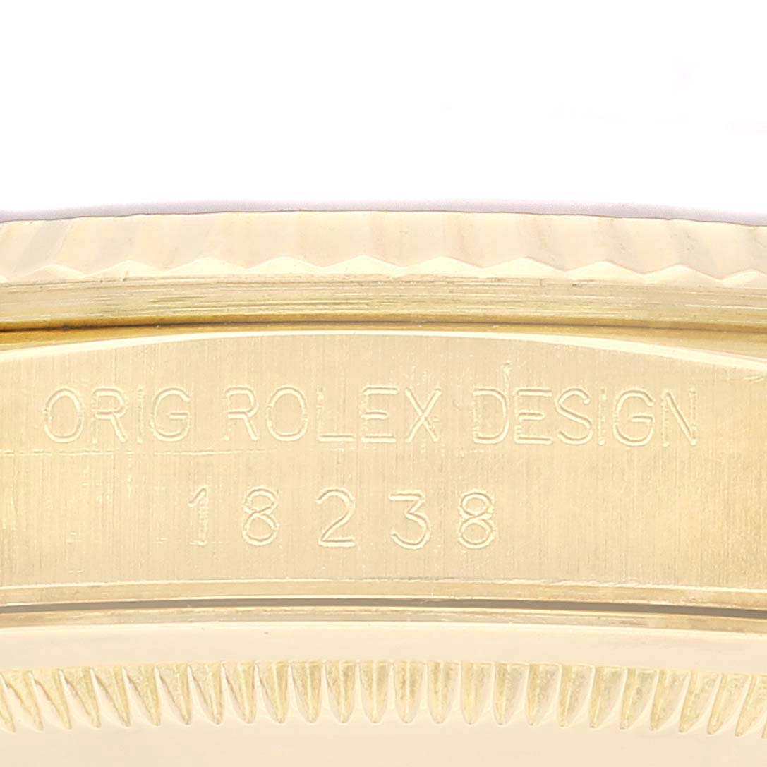 This image shows a close-up of the case side of a Rolex President 18238 Men
s Yellow Gold Champagne Dial 18238 Men
s Yellow Gold Champagne Dial model watch, focusing on the engraved serial number and design.