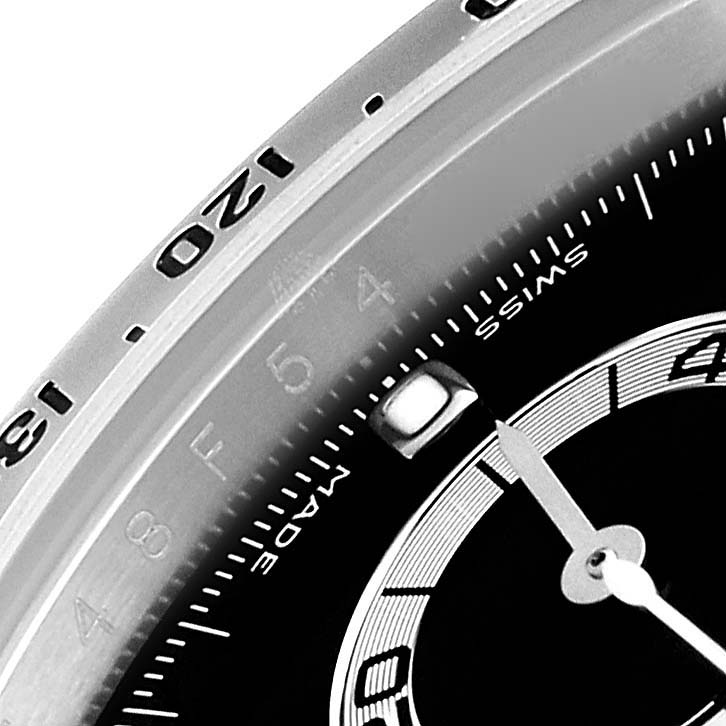 The image shows a close-up of the bezel and part of the dial of a Rolex Daytona 116520 Men
s Stainless Steel Black Dial watch.
