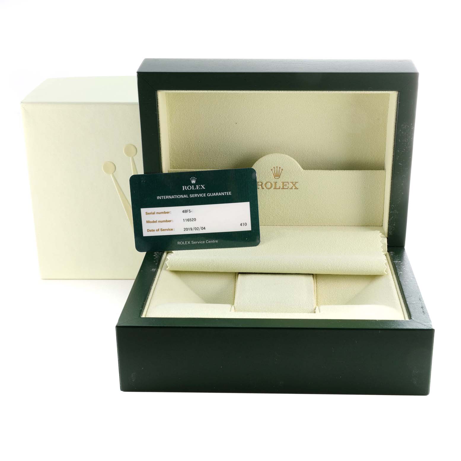 The image shows an open Rolex watch box for a Daytona model, revealing the interior and an international service guarantee card.