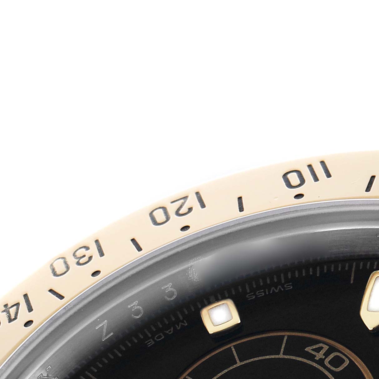 The image shows a close-up of the bezel and part of the dial on a Rolex Daytona 116523 Men
s Steel and Gold (two tone) Black Dial watch.