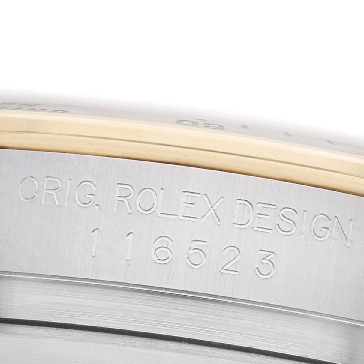 The image shows a close-up of the Rolex Daytona 116523 Men
s Steel and Gold (two tone) Black Dial
s case side with model engraving.