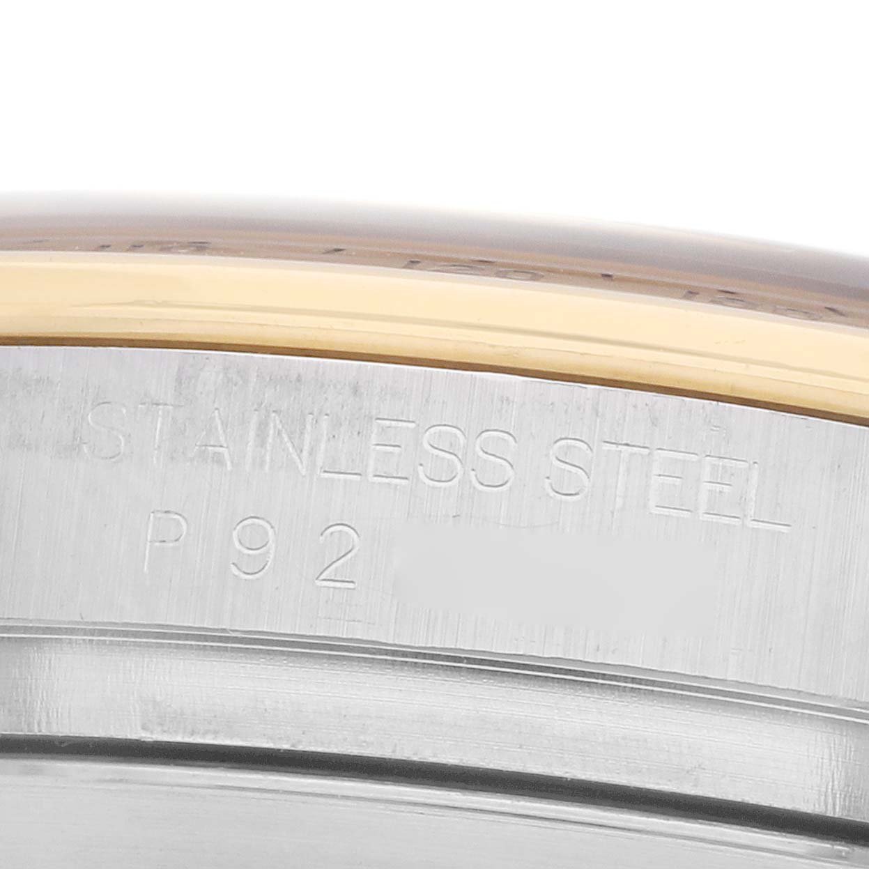 The image shows a close-up of the side of a Rolex Daytona 116523 Men
s Steel and Gold (two tone) Champagne Dial, focusing on the stainless steel engraved section.
