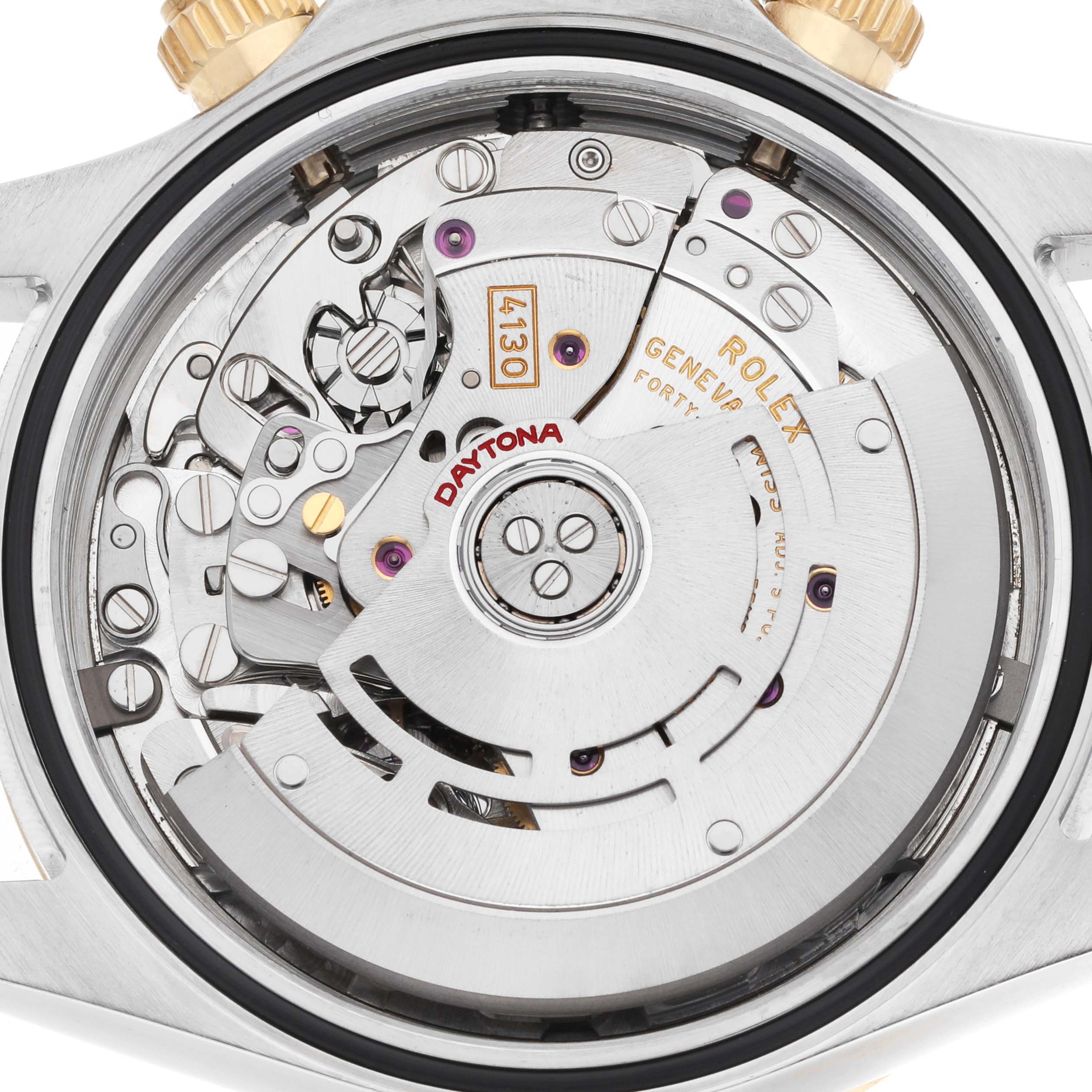 The image shows the back view of a Rolex Daytona 116523 Men
s Steel and Gold (two tone) Silver Dial, highlighting its intricate movement and rotor parts.