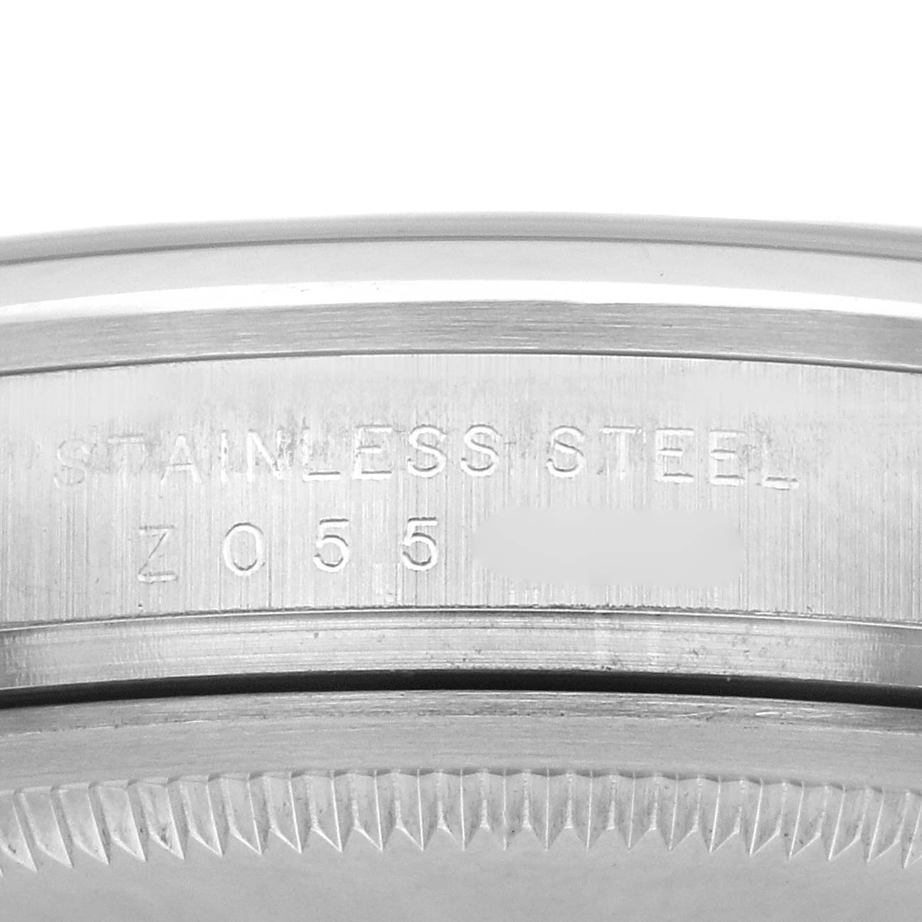 The image shows a close-up side view of the case edge and bezel of a Rolex Explorer 114270 Men
s Stainless Steel Black Dial, highlighting the "STAINLESS STEEL" engraving.