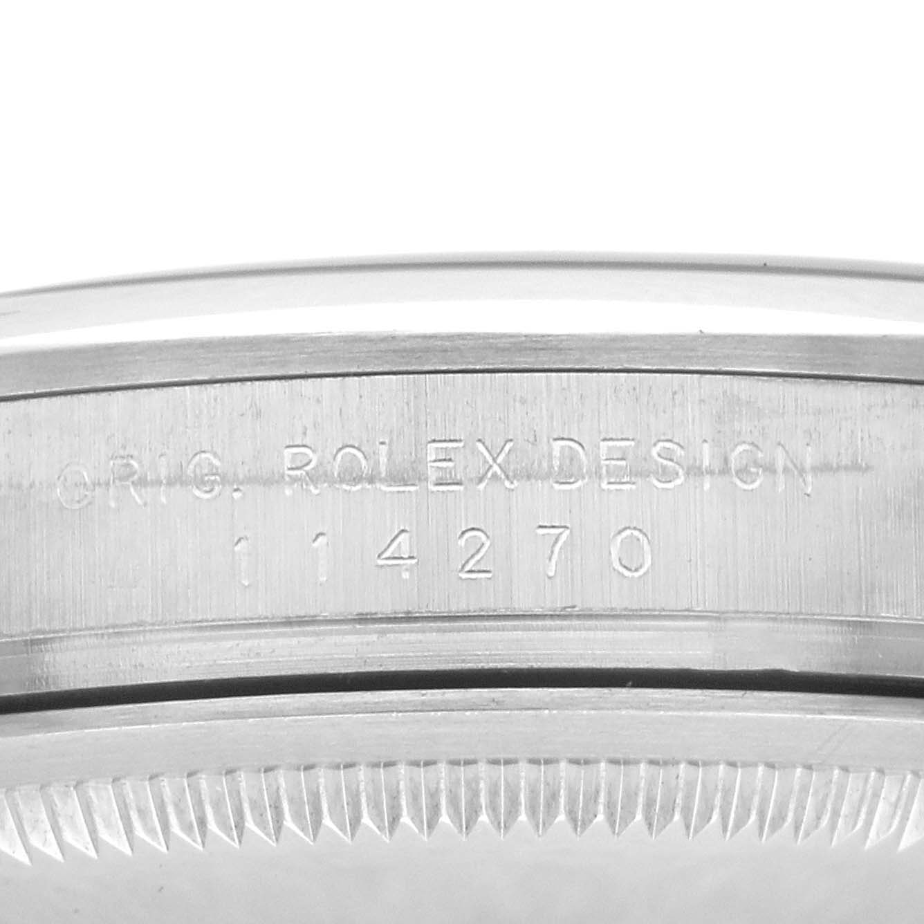 The image shows the side view of a Rolex Explorer 114270 Men
s Stainless Steel Black Dial watch, focusing on the engraved model number and bezel.