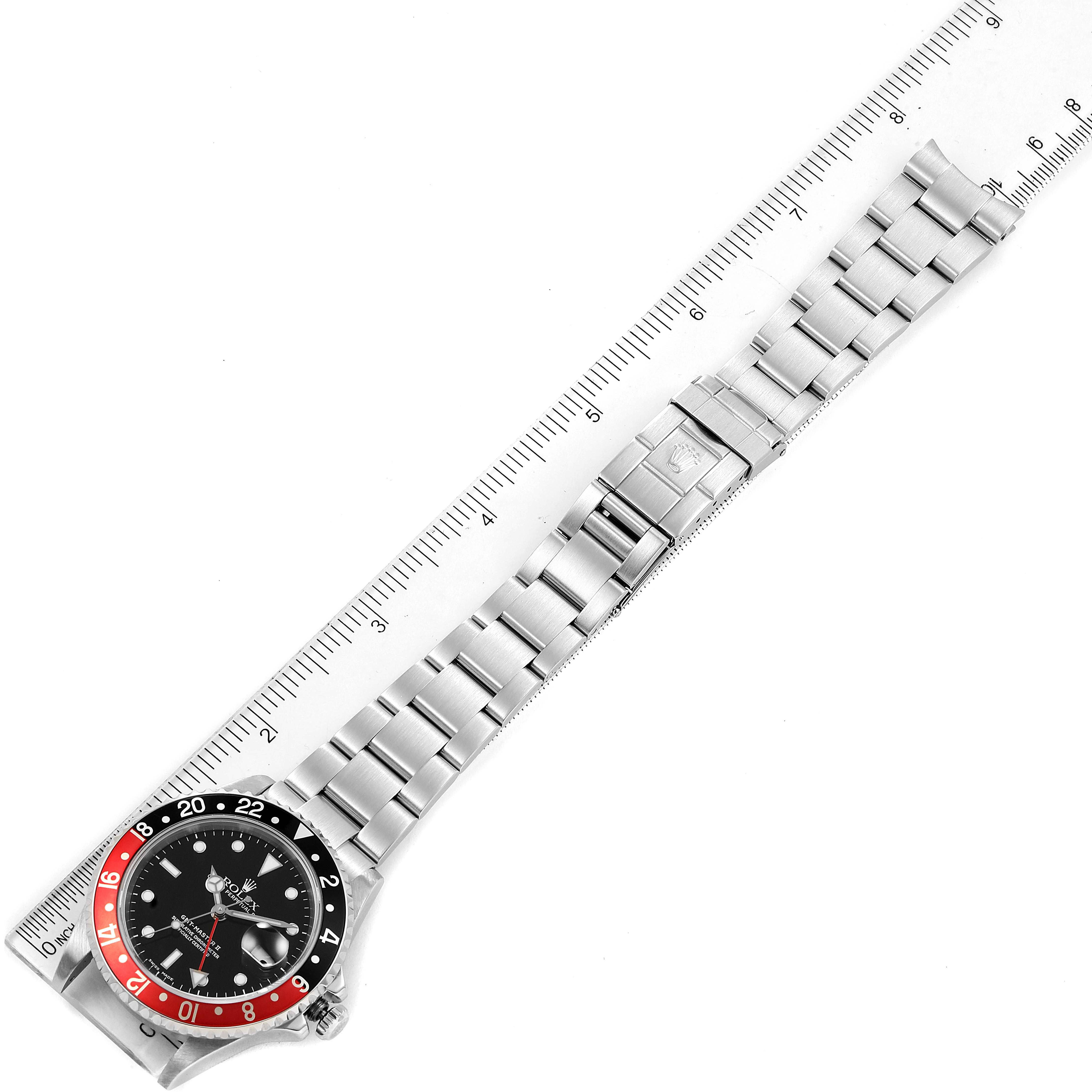 The image shows a top-down angle of a Rolex GMT-Master 16710 Men
s Stainless Steel Black Dial 16710 Men
s Stainless Steel Black Dial watch, displaying the bezel, dial, and the entire bracelet alongside a ruler.