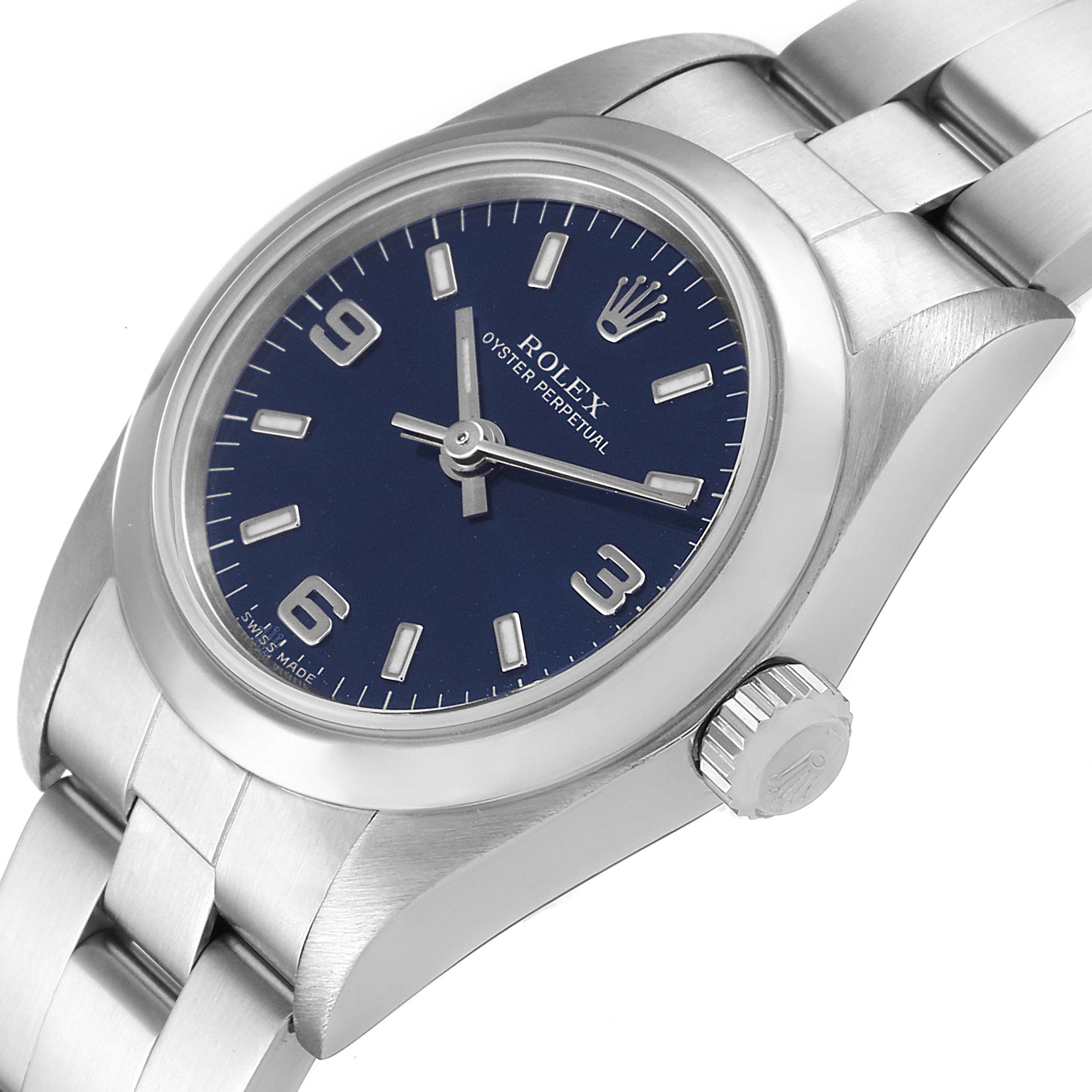 The image shows a Rolex Oyster Perpetual 76080 Women
s Stainless Steel Blue Dial 76080 Women
s Stainless Steel Blue Dial watch at an oblique angle, displaying the face, crown, and part of the bracelet.