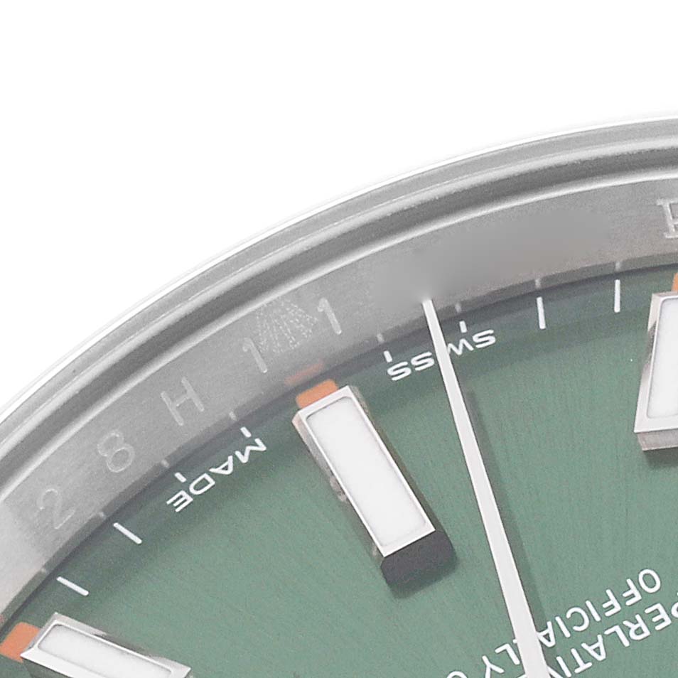 This image shows a close-up of the dial and part of the bezel of a Rolex Oyster Perpetual 114200 Men
s Stainless Steel Green Dial 114200 Men
s Stainless Steel Green Dial watch.