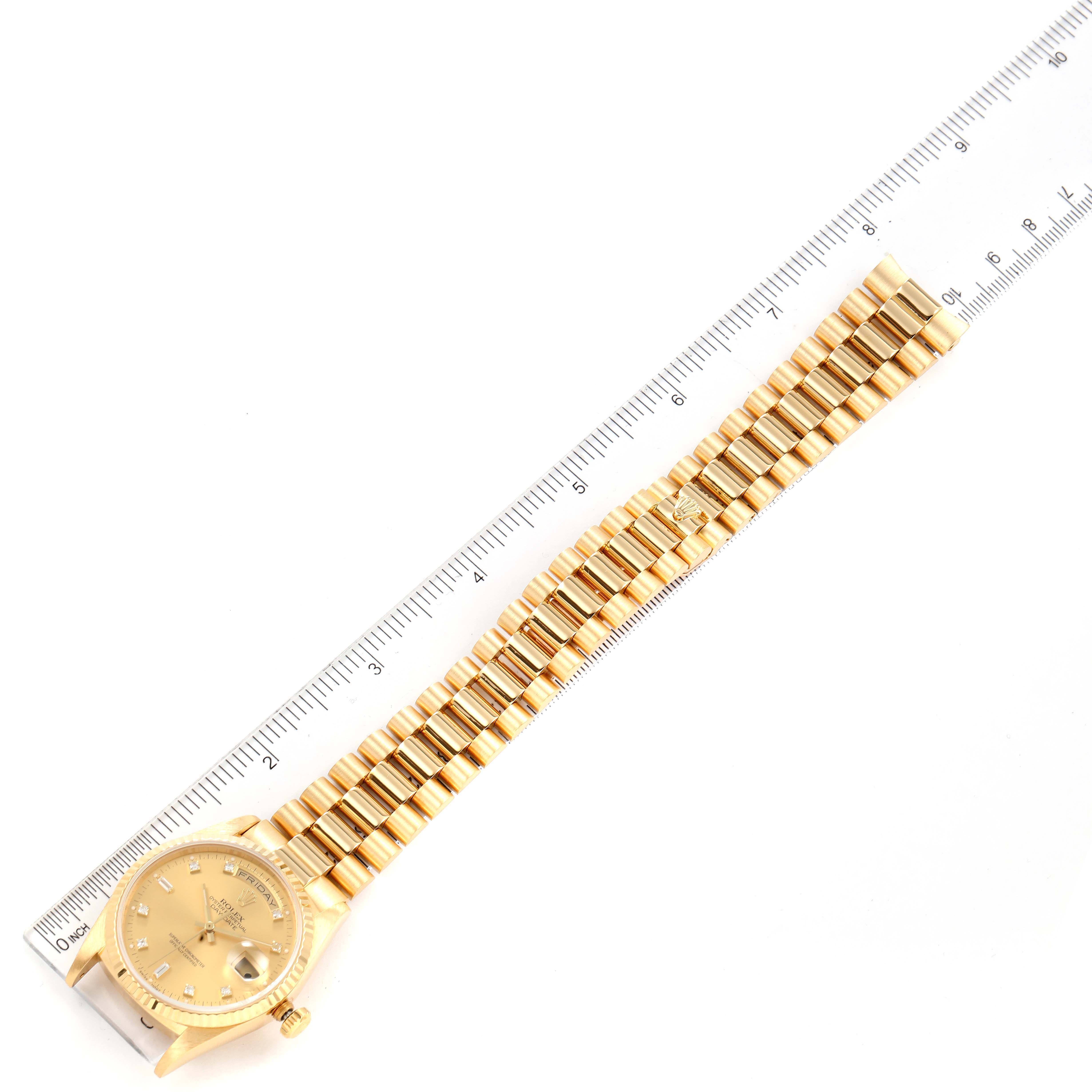 The image shows a Rolex President 18238 Men's Yellow Gold Champagne Dial 18238 Men's Yellow Gold Champagne Dial model watch laid flat next to a ruler, highlighting its gold bracelet and face.