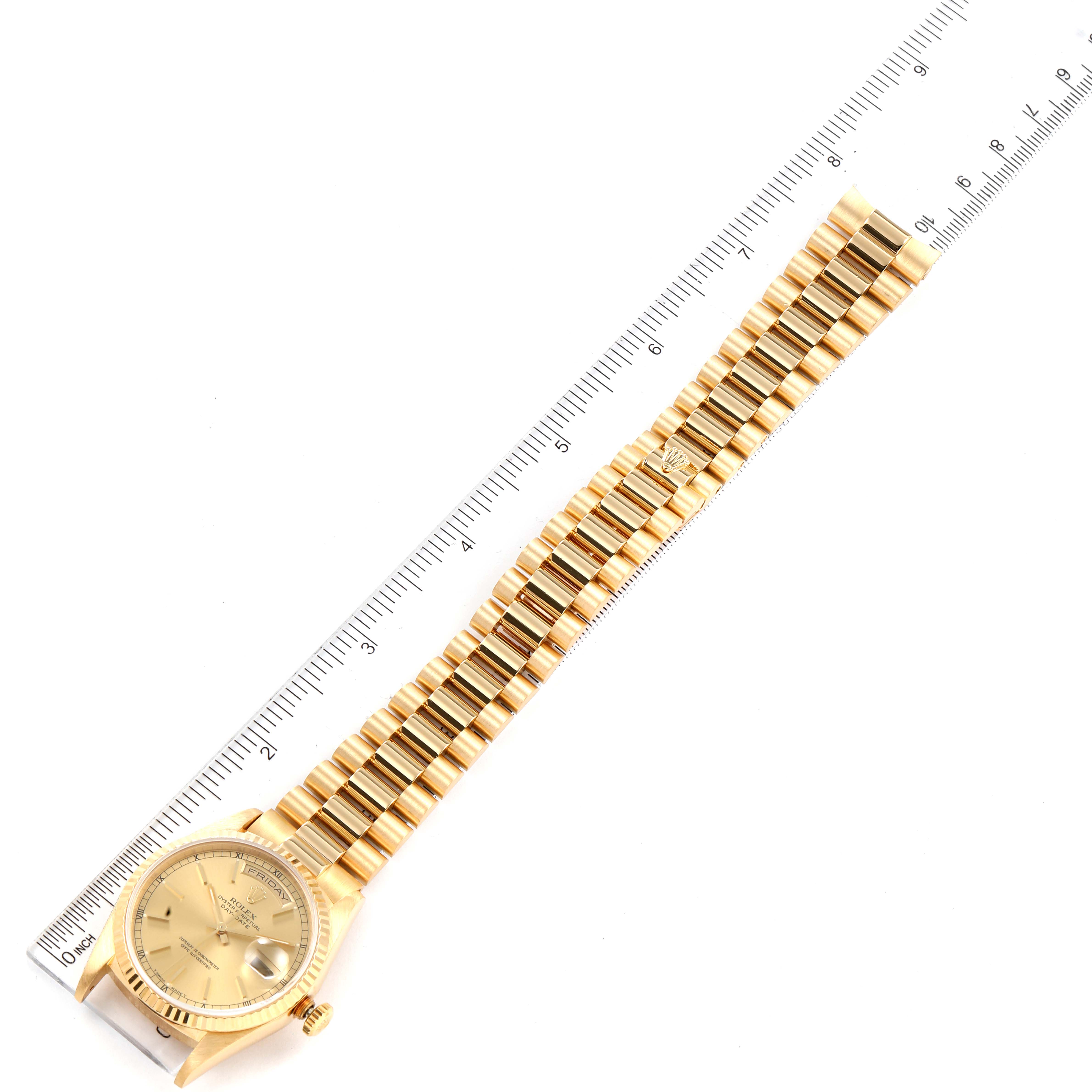 The image shows a top-down view of a Rolex President 18238 Men
s Yellow Gold Champagne Dial 18238 Men
s Yellow Gold Champagne Dial model watch, fully displaying the face and bracelet beside a ruler.