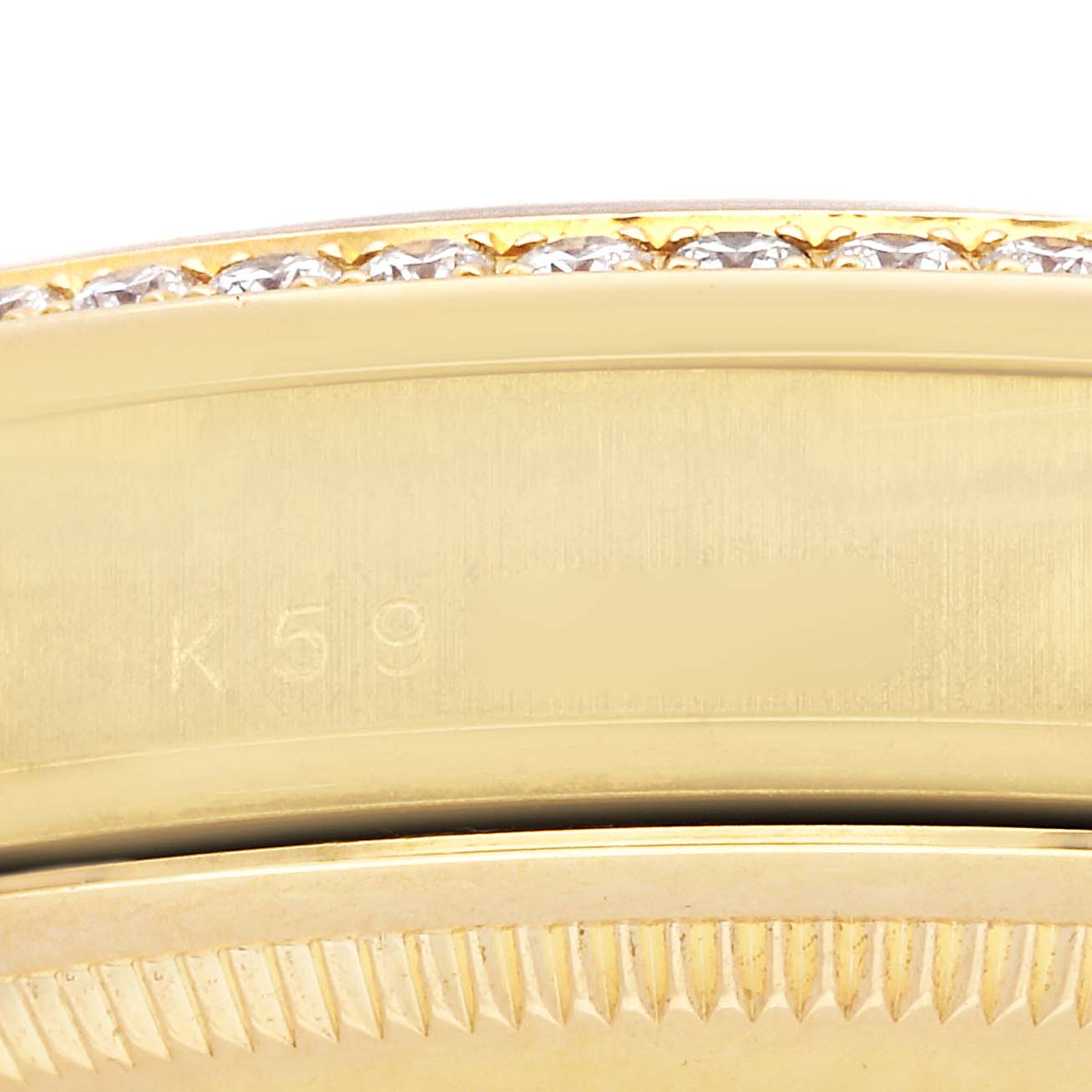 The image shows a close-up of the Rolex President 118388 Men
s Yellow Gold Mother of Pearl Dial watch’s gold case edge with diamond detailing and inscription.