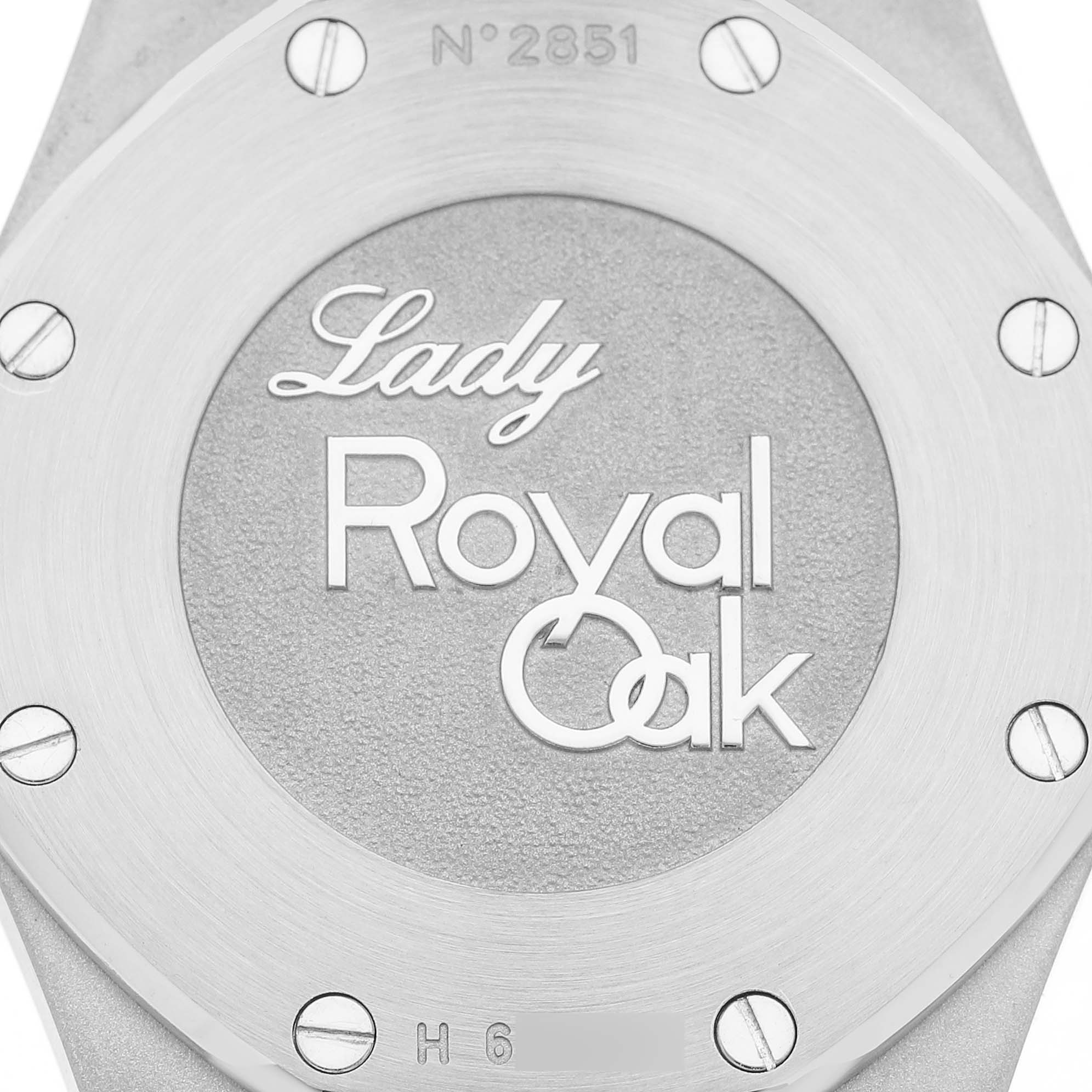 The image shows the case back of the Audemars Piguet Royal Oak 77321ST.ZZ.D002CR.01 Women's Stainless Steel Black Dial Lady model, highlighting the engraved text and screws.