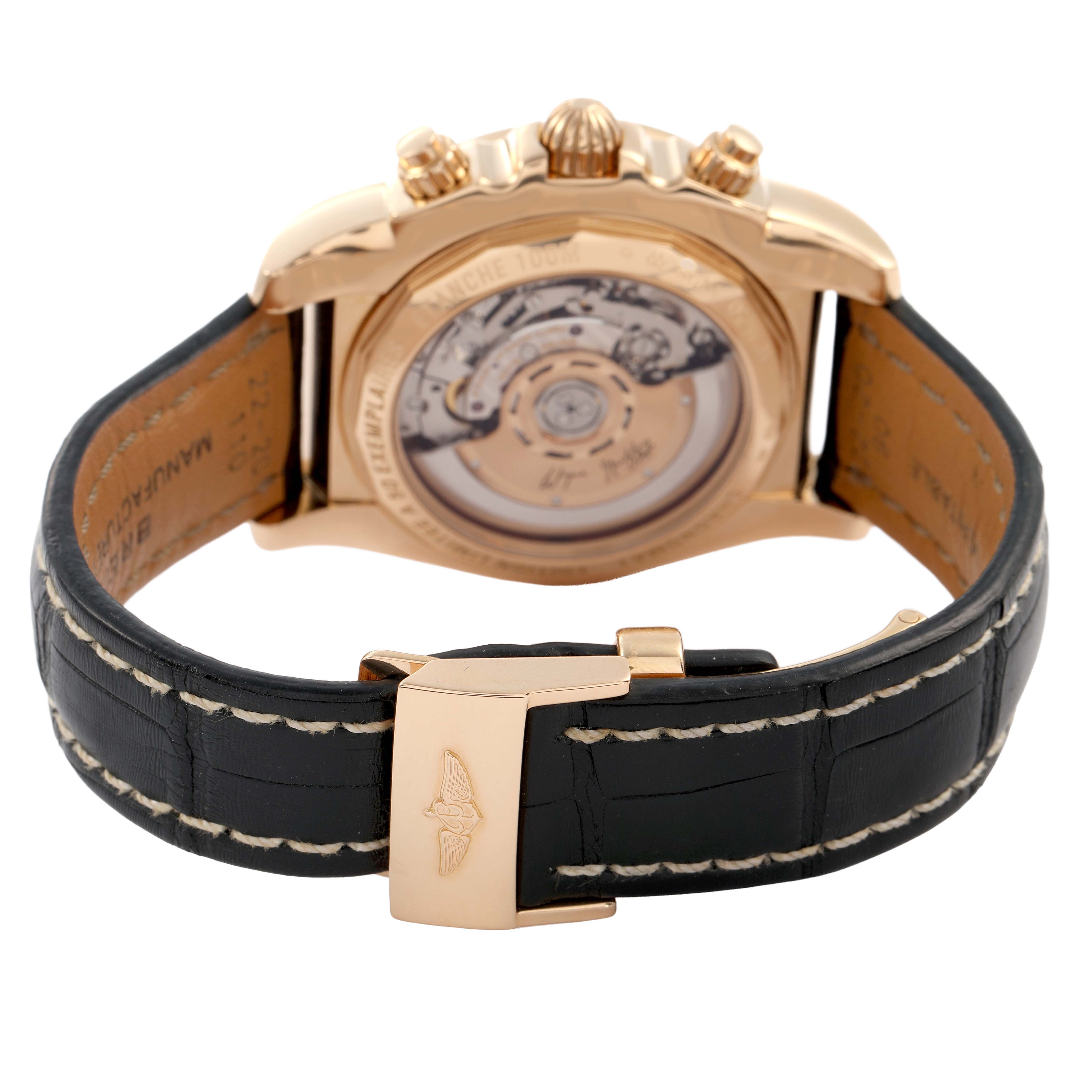The Breitling Chronomat HB01115W/BE53 Men's Yellow Gold Black Dial watch is shown from the rear, displaying its movement and leather strap with a visible clasp.